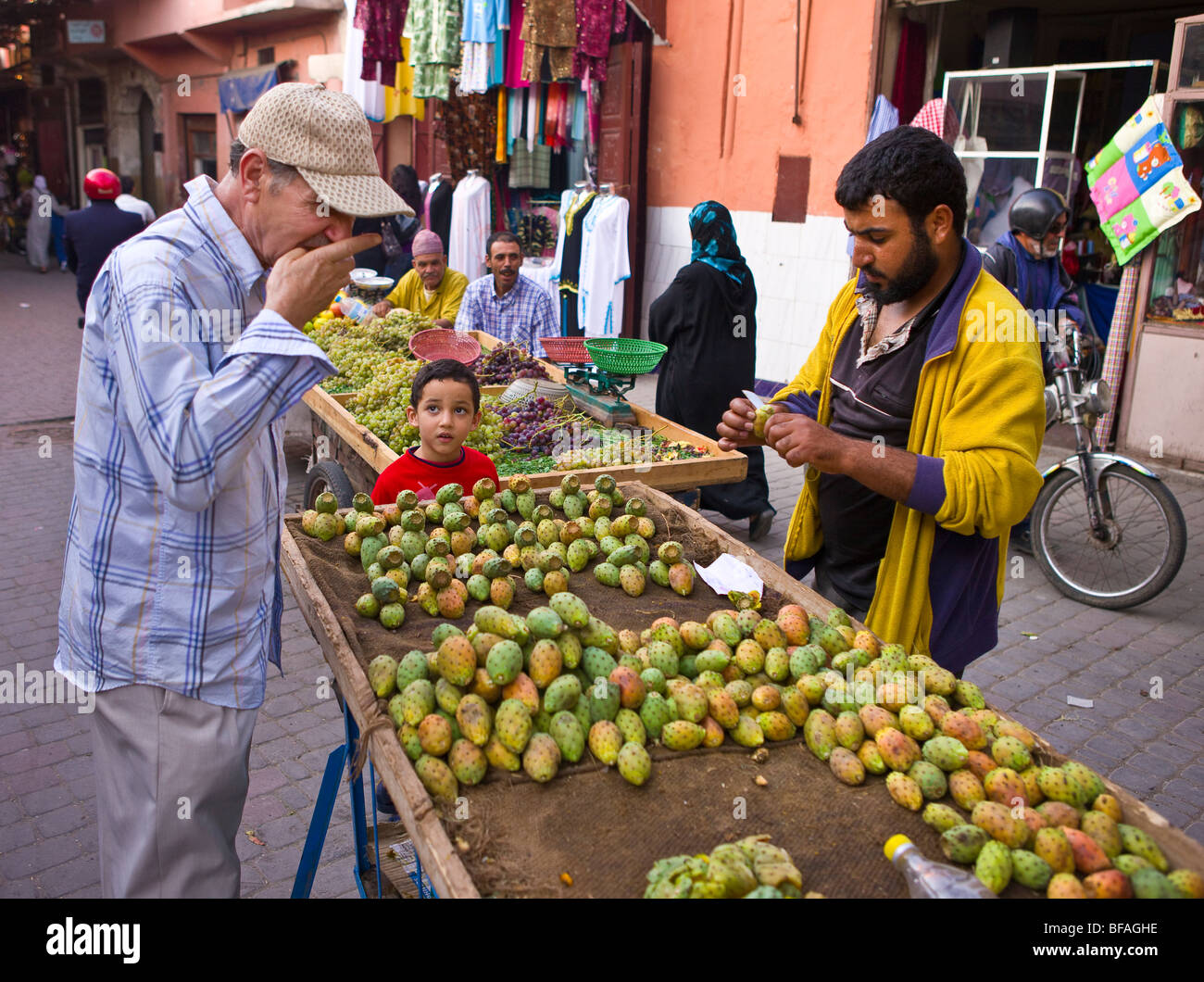 Marrakesch, Marokko - Mann schmeckt Kaktus Frucht von Straßenhändler in Medina. Stockfoto