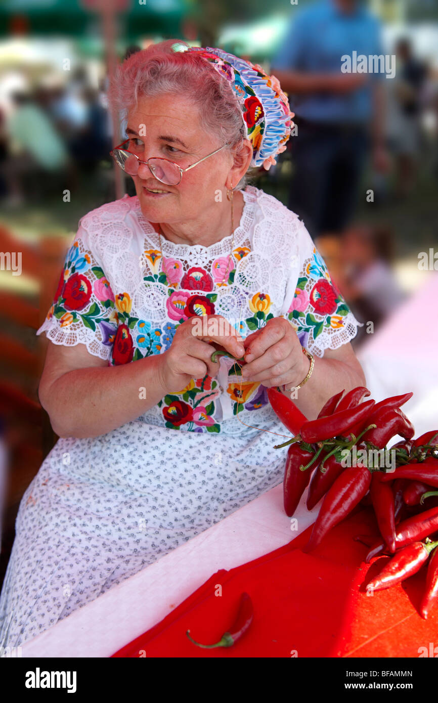 Alte Frauen in traditionellen Kalocsa Kleid auf dem Paprka Festival Strings von Chilis machen. Kalocsa, Ungarn Stockfoto