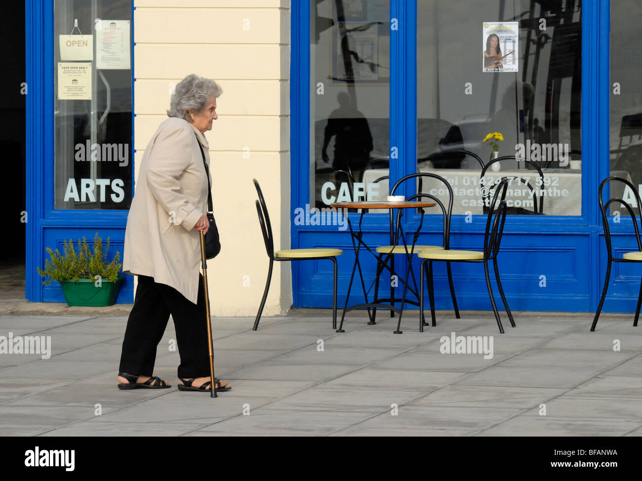 Hastings, East Sussex, England, UK. Alte Frau mit Gehstock, vorbei an der Kunst-Cafe an der Marine Parade Stockfoto