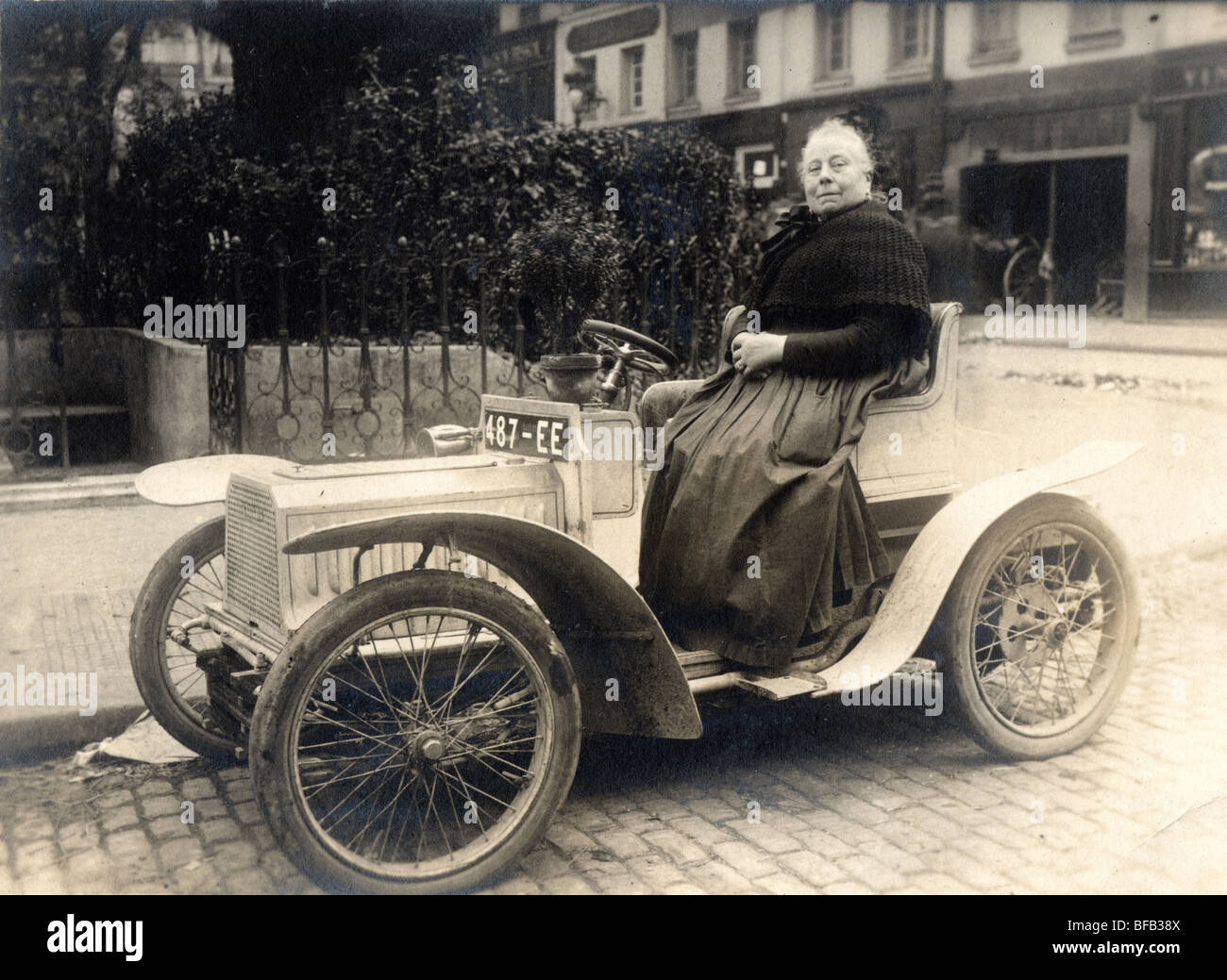 Große alte Dame winzige Auto fahren Stockfoto