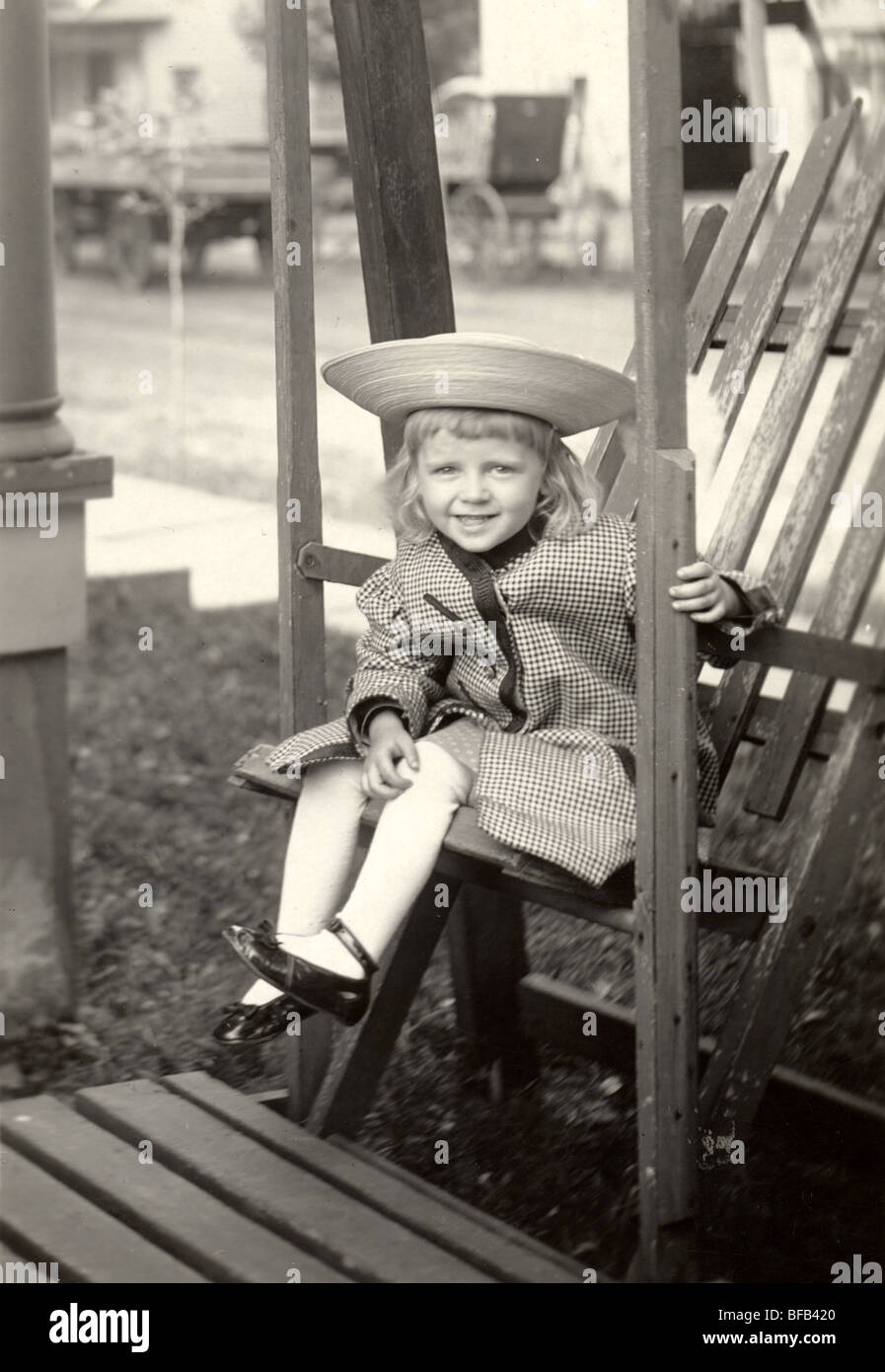 Kleines Mädchen in runden Hut sitzt auf Schaukel Stockfoto