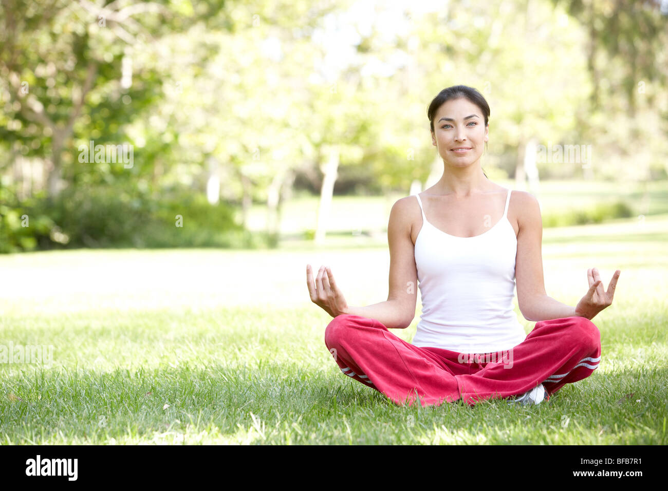 Junge Frau beim Yoga im Park Stockfoto