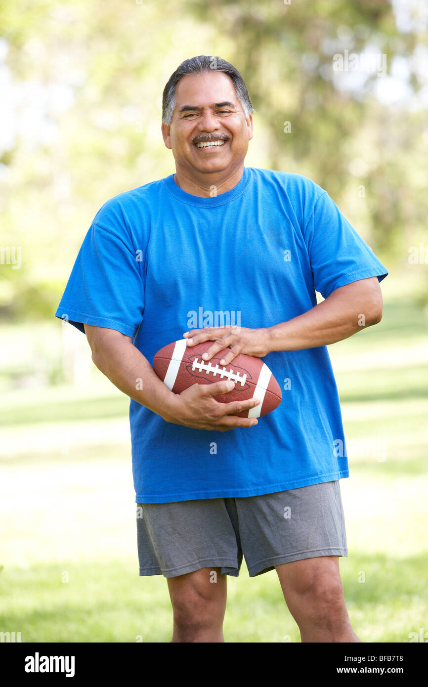 Senior woman Training mit American Football im Park Stockfoto
