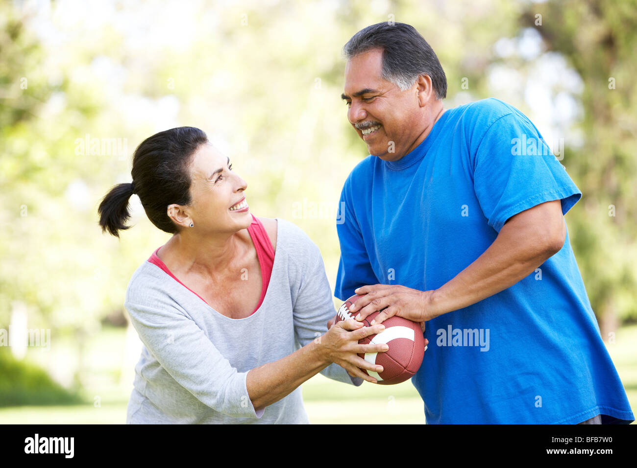 Älteres Paar Training mit American Football im Park Stockfoto