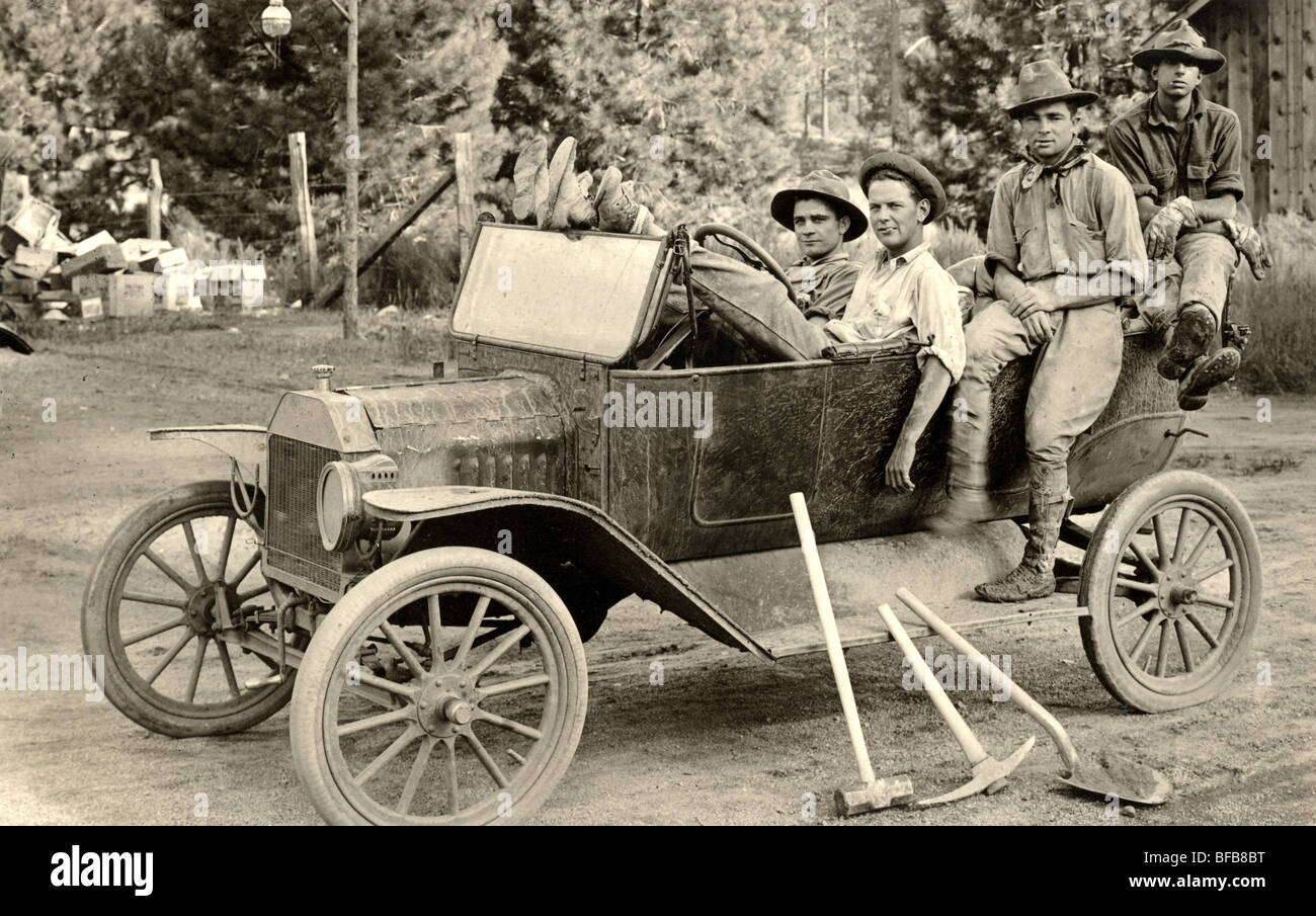 Vier Arbeiter mit Werkzeugen in Ford Modell T Stockfoto
