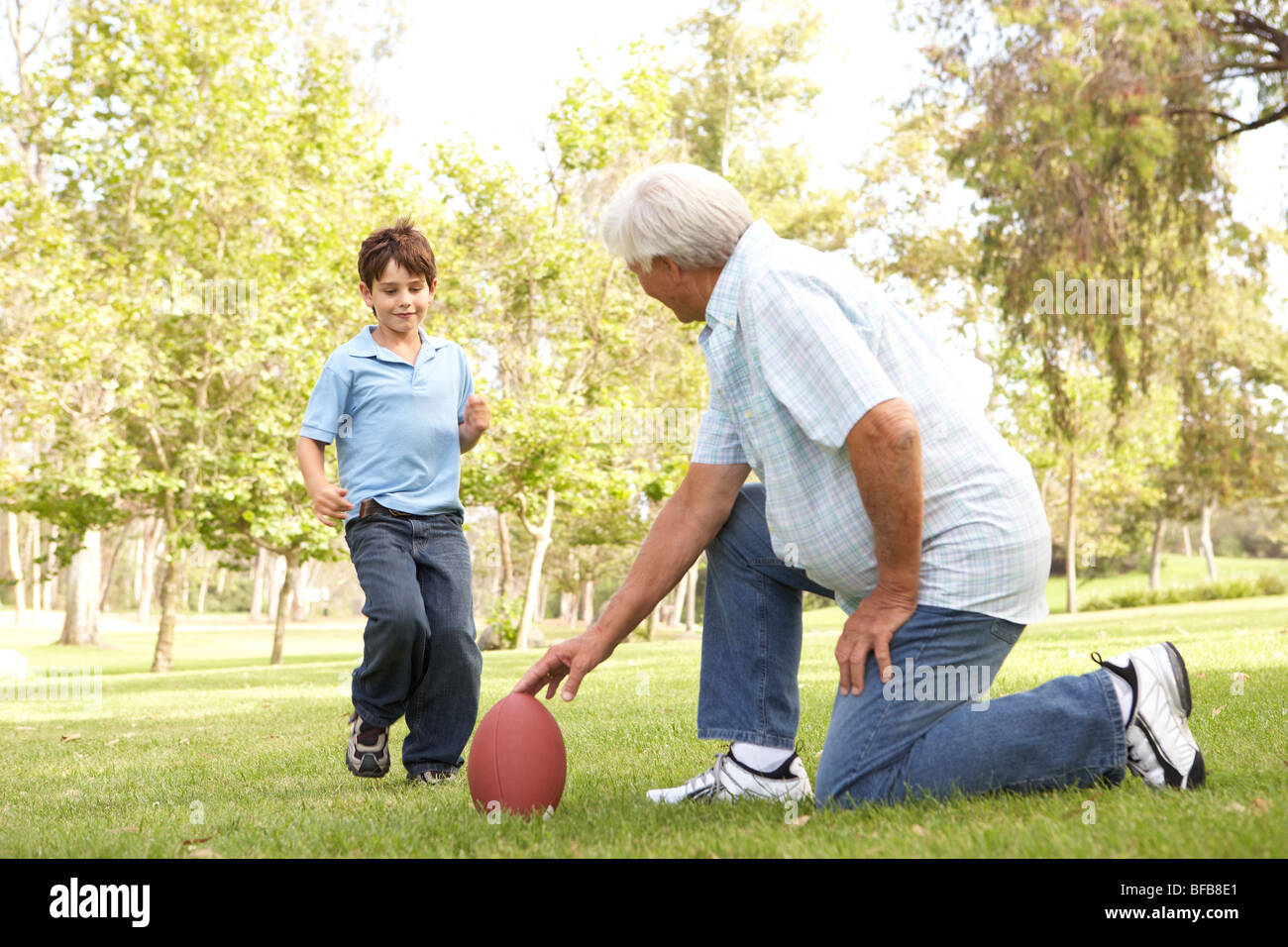 Großvater und Enkel spielen American Football Stockfoto