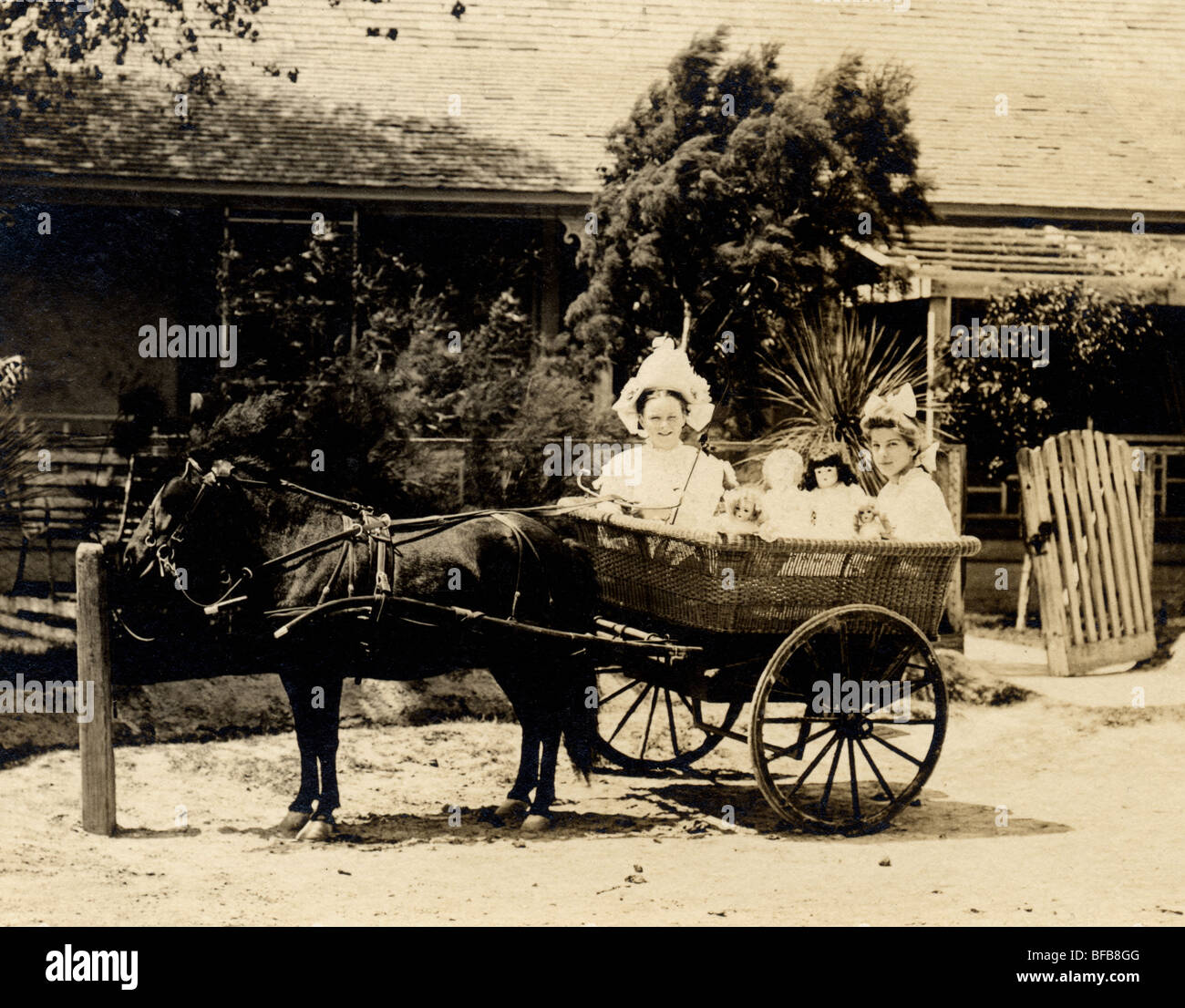 Zwei Mädchen fahren Wicker Pony Warenkorb Stockfoto