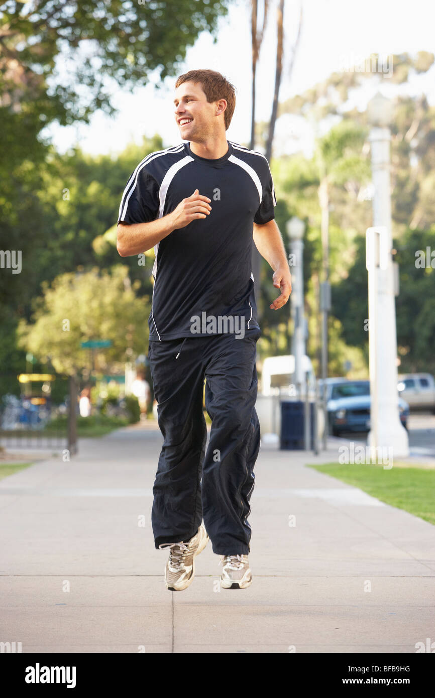 Junger Mann Joggen auf der Straße Stockfoto