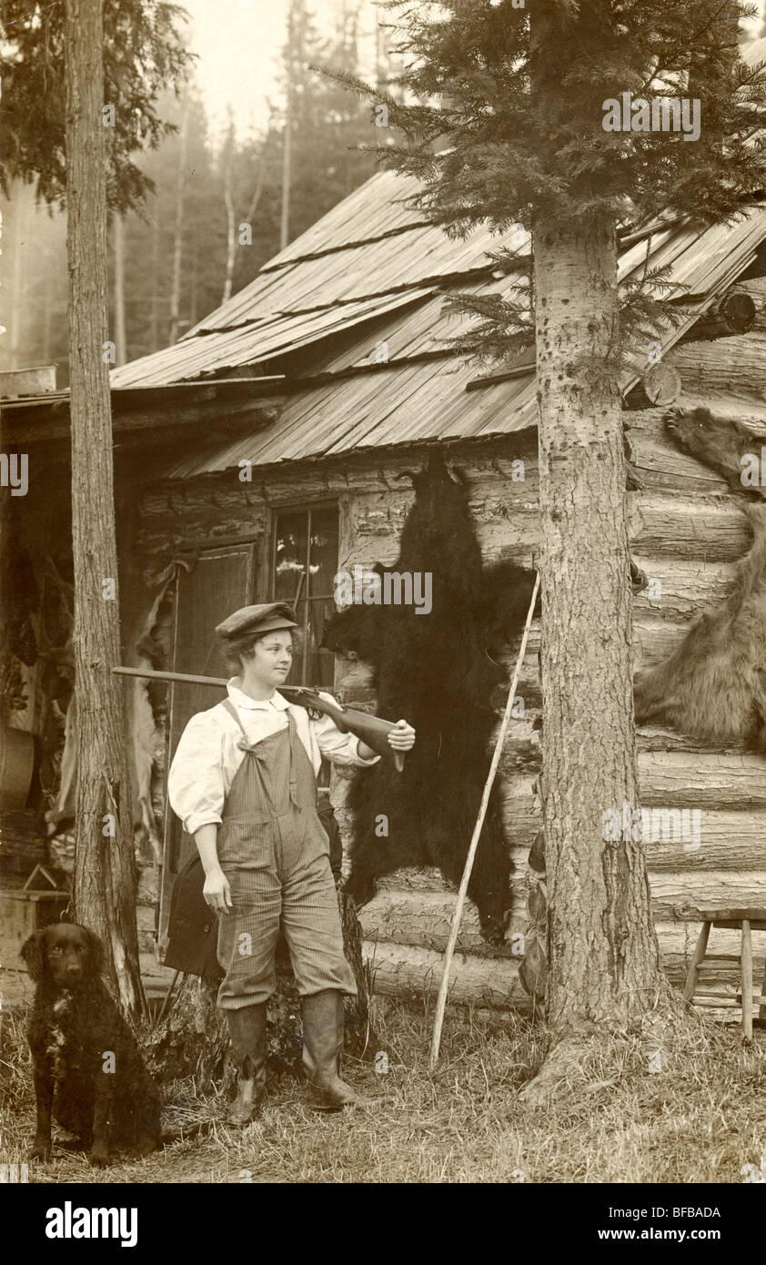 Frontier Mädchen Jäger mit Flinte in Blockhütte Stockfoto