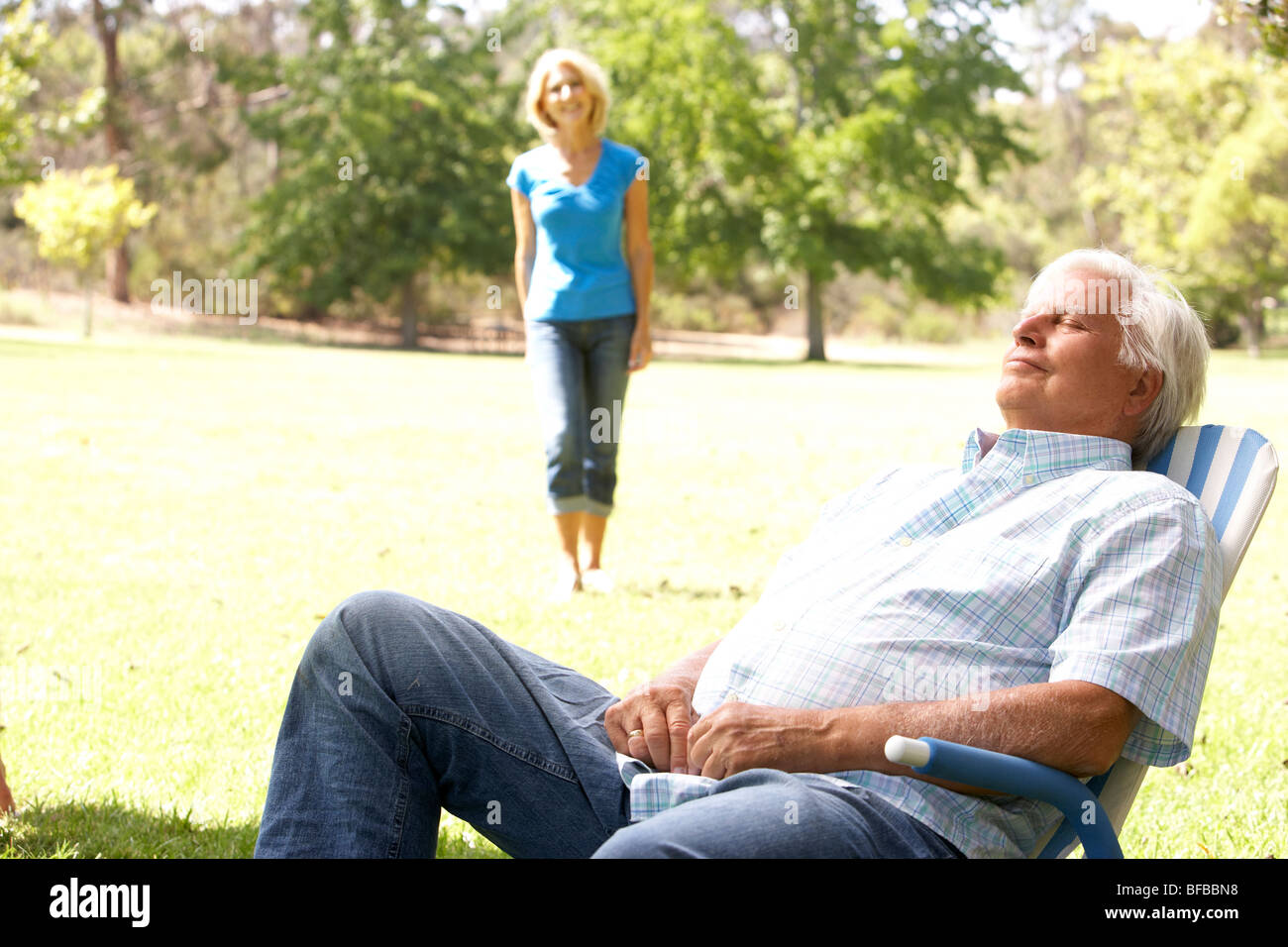 Entspannen im Park mit Frau im Hintergrund Senior woman Stockfoto