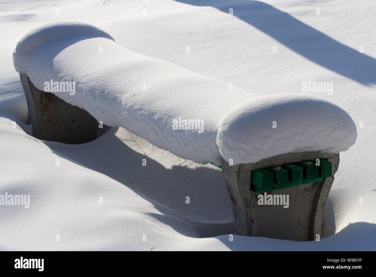 Beton und Holz Bank unter der Schneedecke Stockfoto