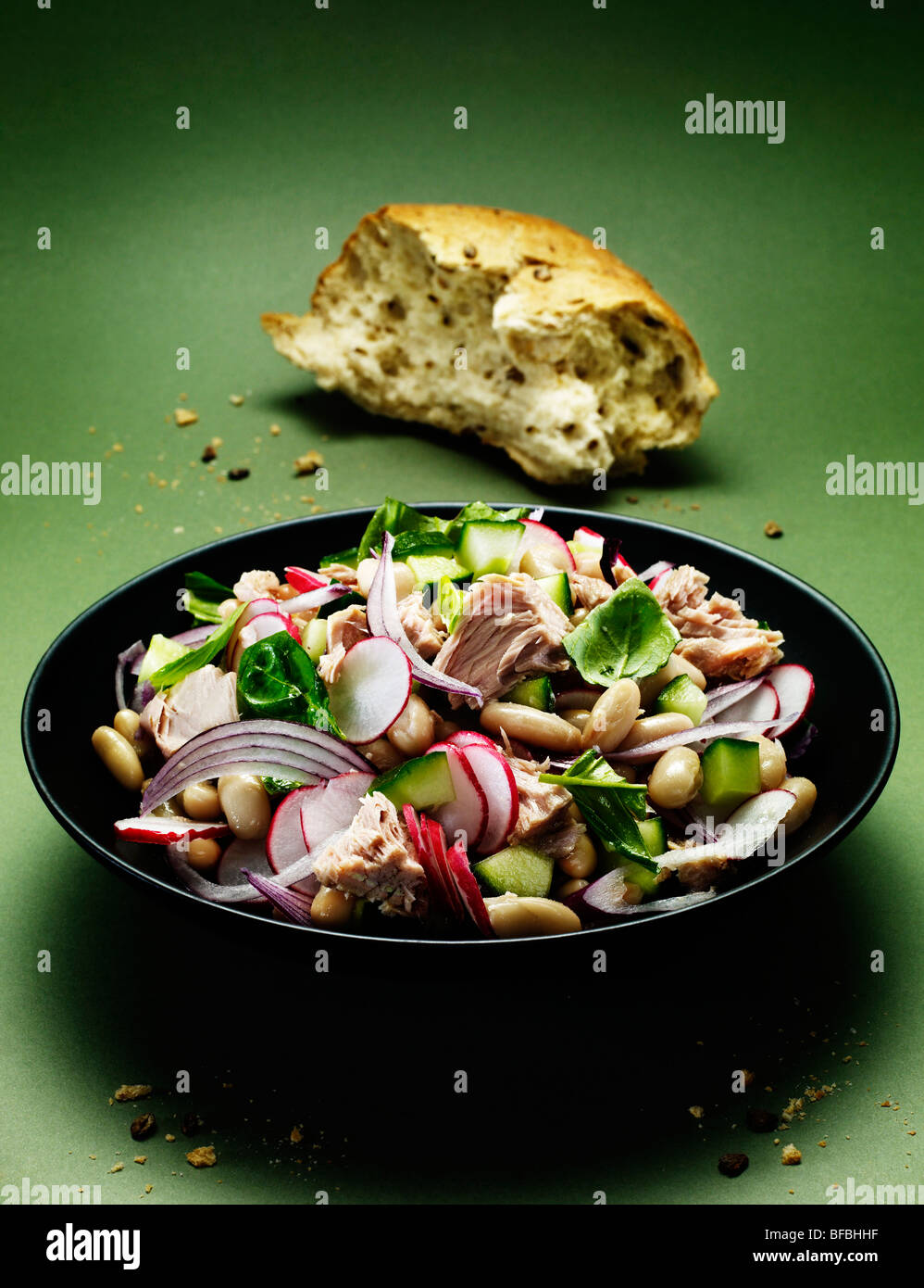 Thunfisch und Cannellini-Salat mit roten Zwiebeln, Basilikum, Radieschen und Gurken Server mit Vollkornbrot. Stockfoto