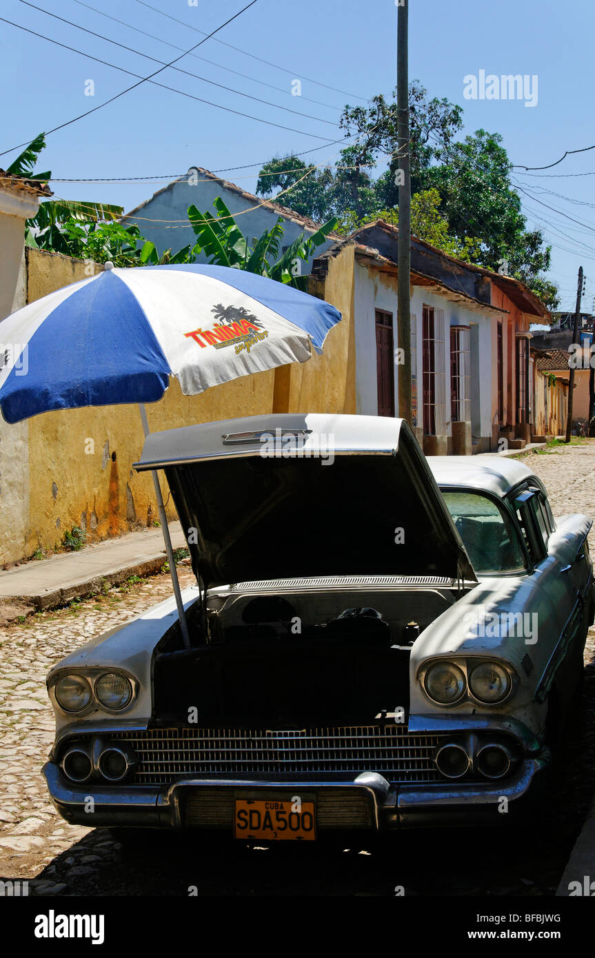 Klimaanlage, Cuban Style, Trinidad, Kuba. Ein Sonnenschirm im Motorraum eines klassischen Amerikanischen Auto Schattierung Stockfoto