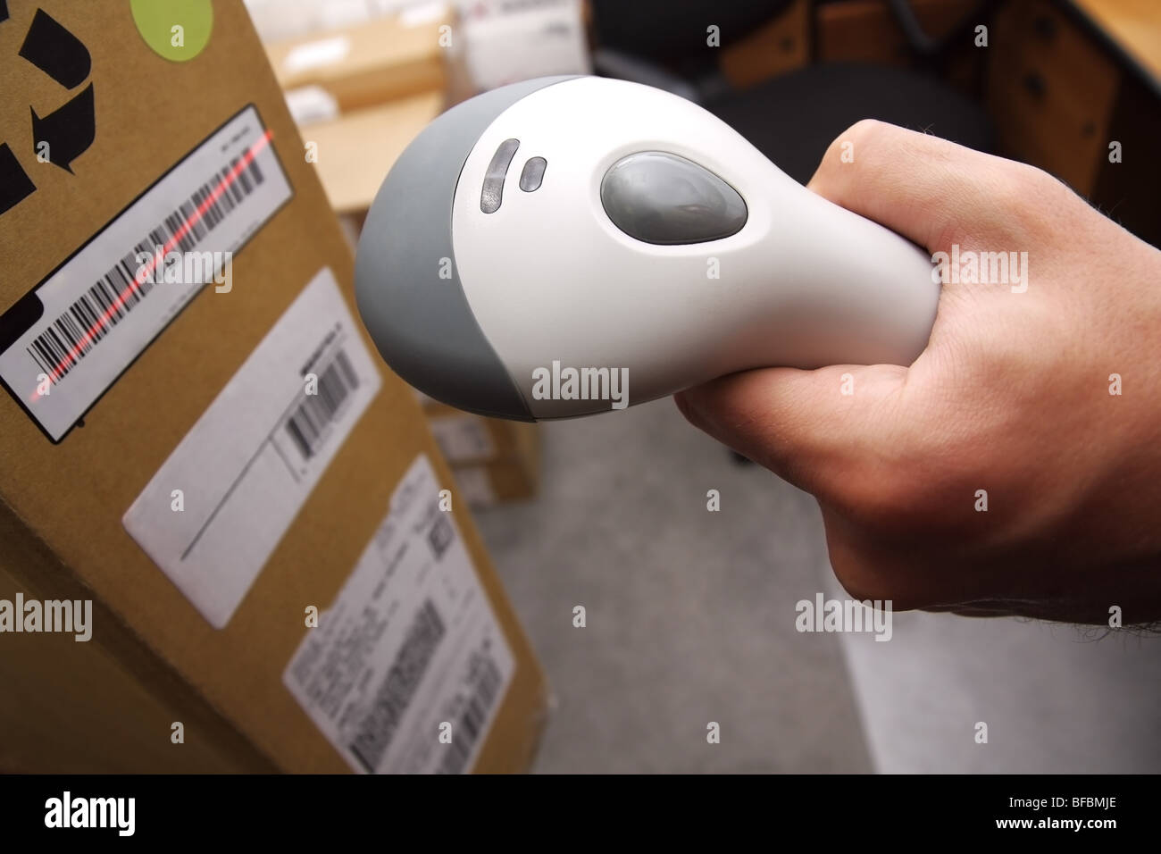 Ein Mann bekommt auf der Hüfte Scaner in Operationen auf gedruckten Barcode gerichtet. Lager-Szene. Stockfoto