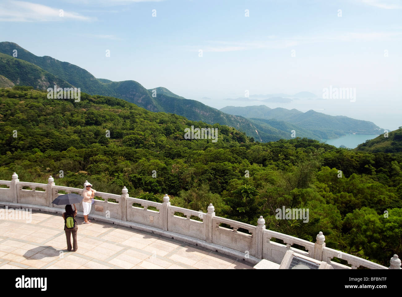 Blick vom Tian Tan Big Buddha mit Frau posiert für ein Foto, Lantau Island, Hong Kong Stockfoto