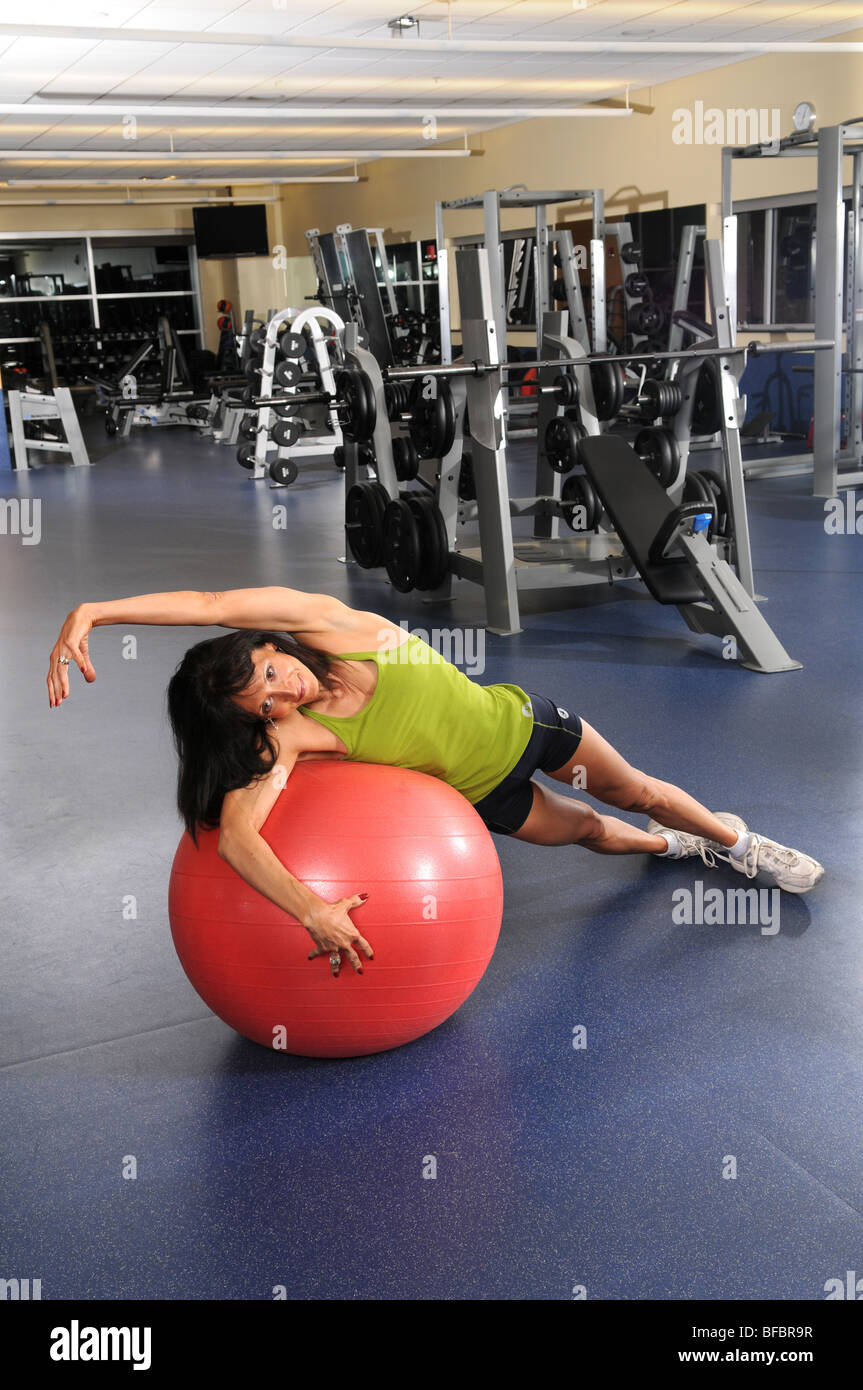 Frau in der Turnhalle erstreckt sich über Fitness-ball Stockfoto