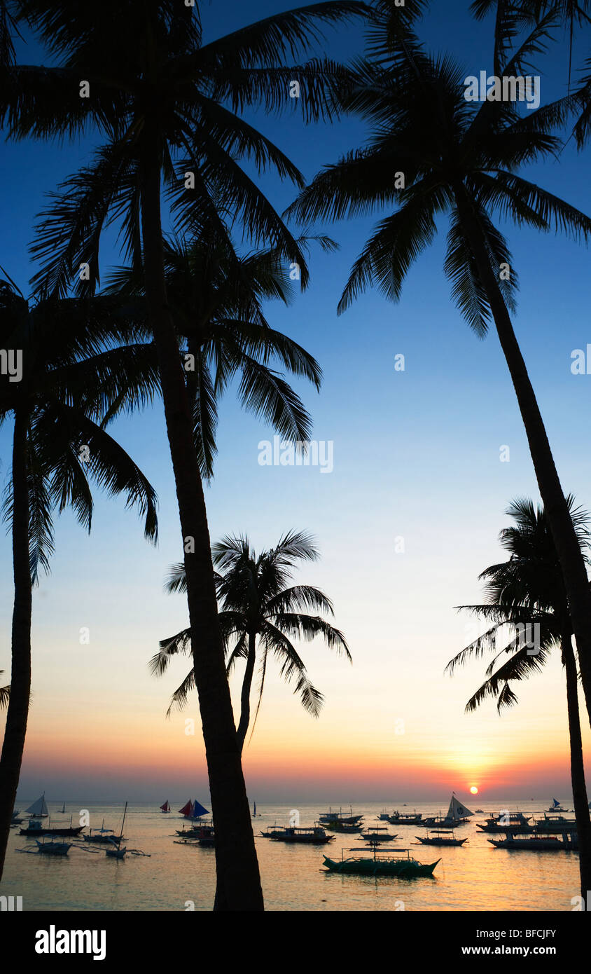 Palmen und Boote auf dem Meer, Sonnenuntergang Boracay; Die Visayas; Philippinen. Stockfoto