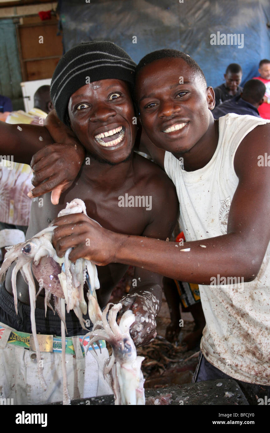 Junge Männer mit gemeinsamen Octopus zum Verkauf an Kivukoni Fischmarkt, Dar-Es-Salaam, Tansania Stockfoto