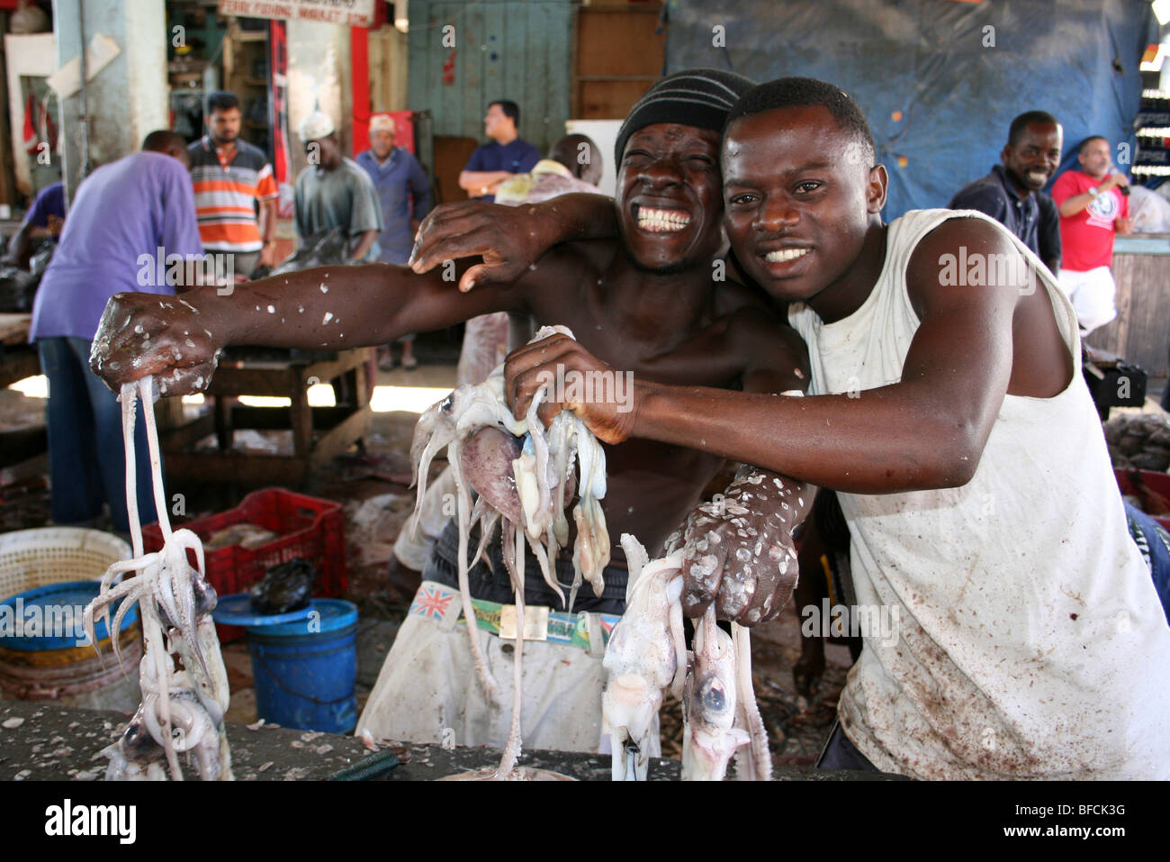 Junge Männer mit gemeinsamen Octopus zum Verkauf an Kivukoni Fischmarkt, Dar-Es-Salaam, Tansania Stockfoto