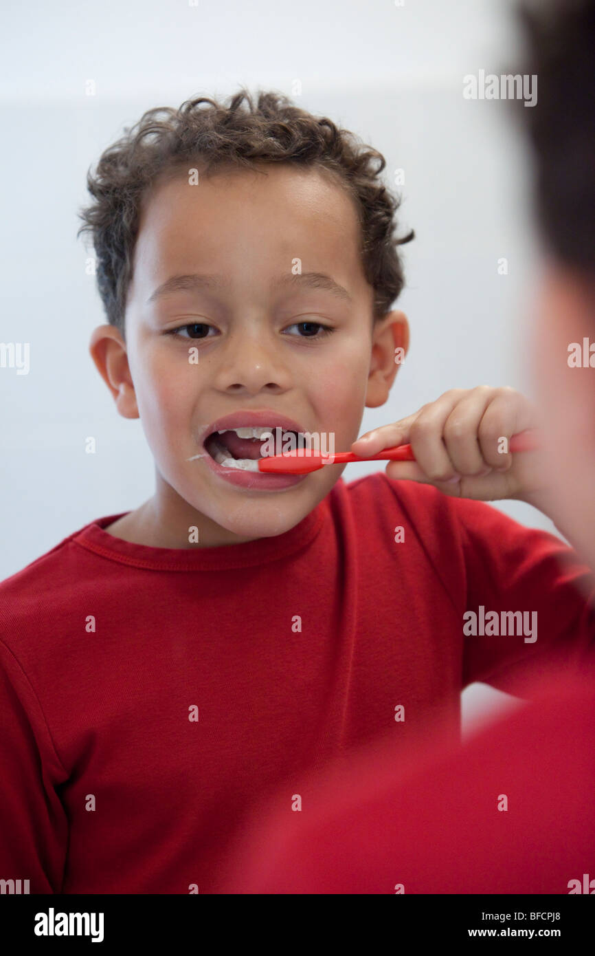 Sieben Jahre alter Junge, seine Zähne zu putzen Stockfoto