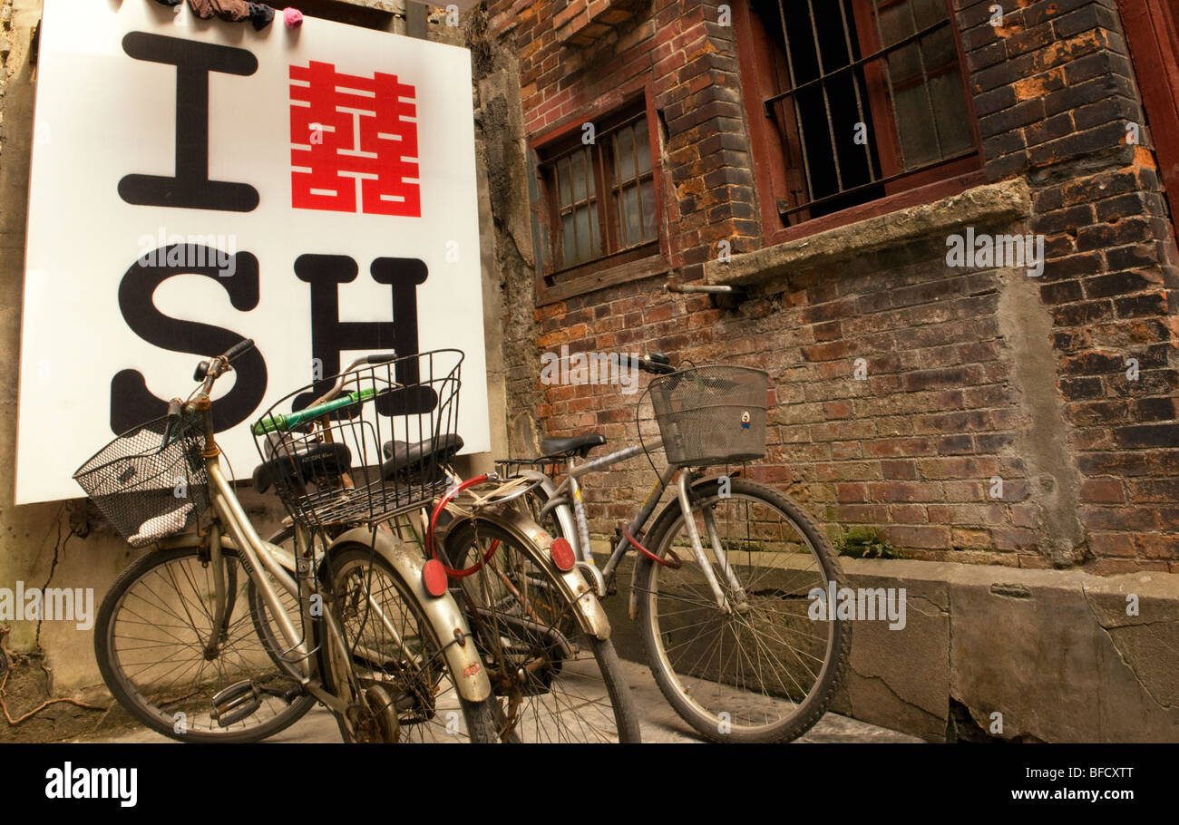 Fahrräder geparkt vor einem ich liebe Shanghai Zeichen in einer Gasse in Shanghai China Stockfoto