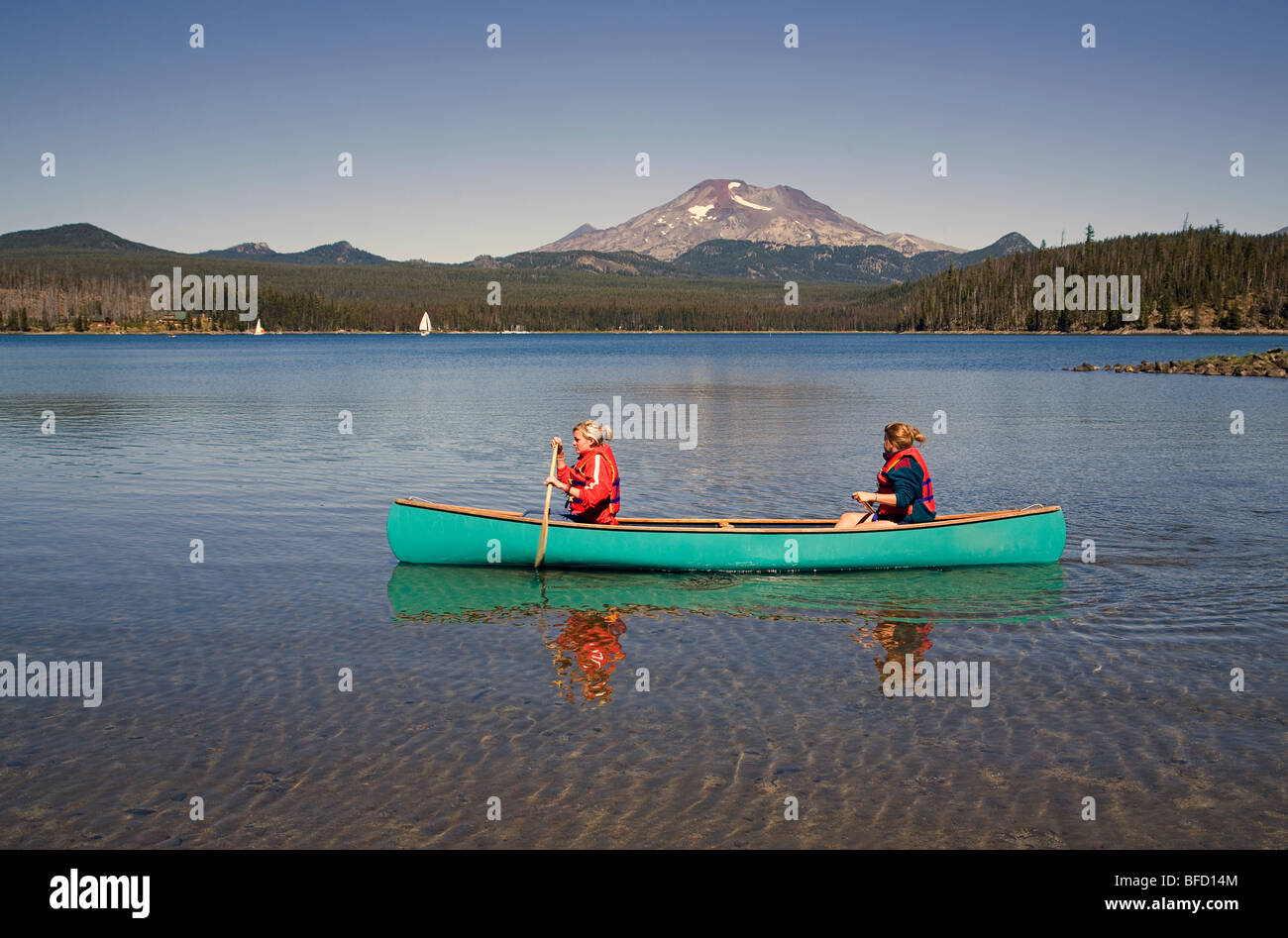 Zwei Teenager im Alter von Mädchen in einem Kanu auf Elk Lake in Oregon Cascade Mountains entlang der Cascade-Seen-Autobahn Stockfoto