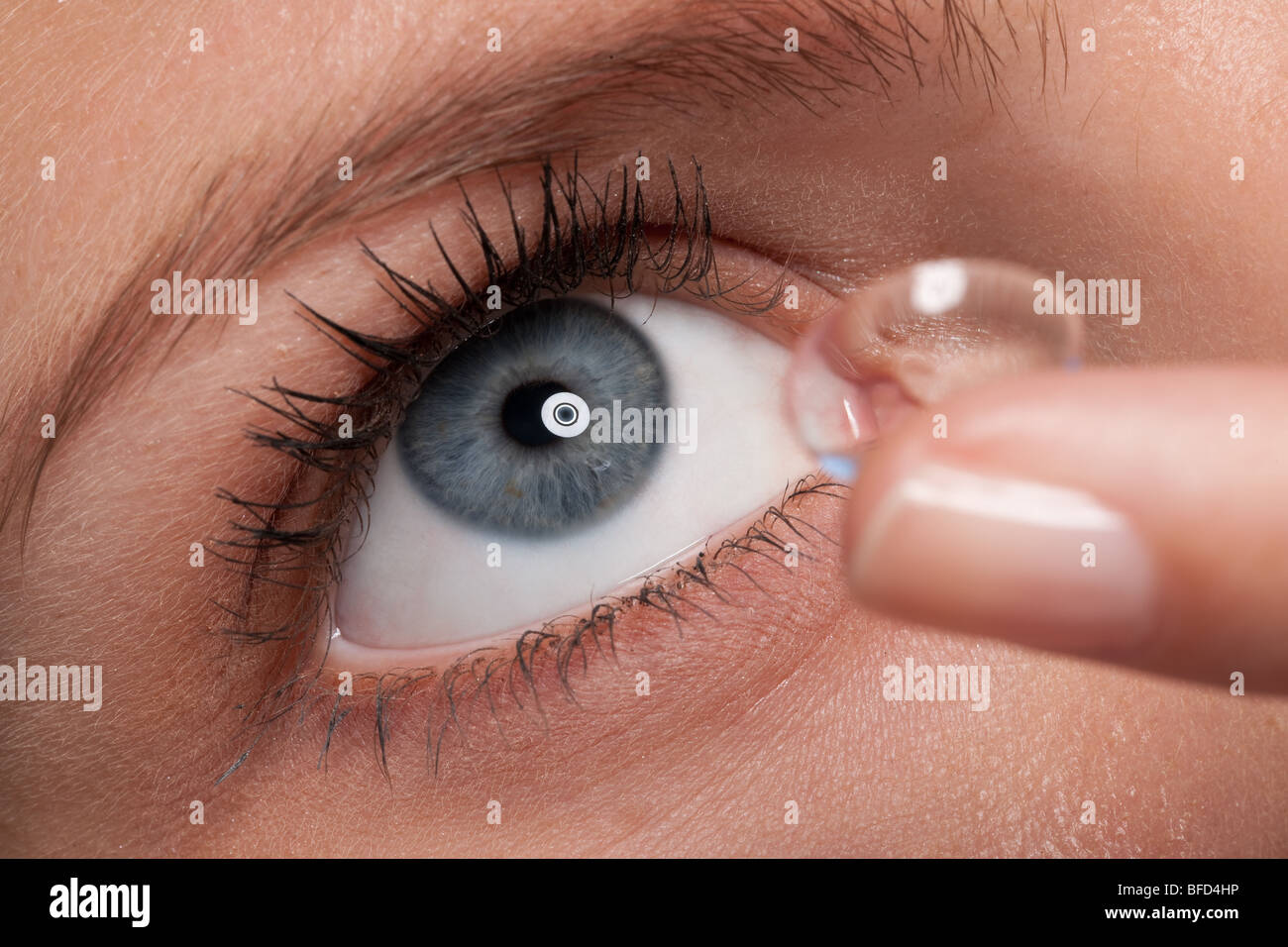 Nahaufnahme der blauen Frau Auge mit Kontaktlinsen anwenden, Makro-Objektiv Stockfoto