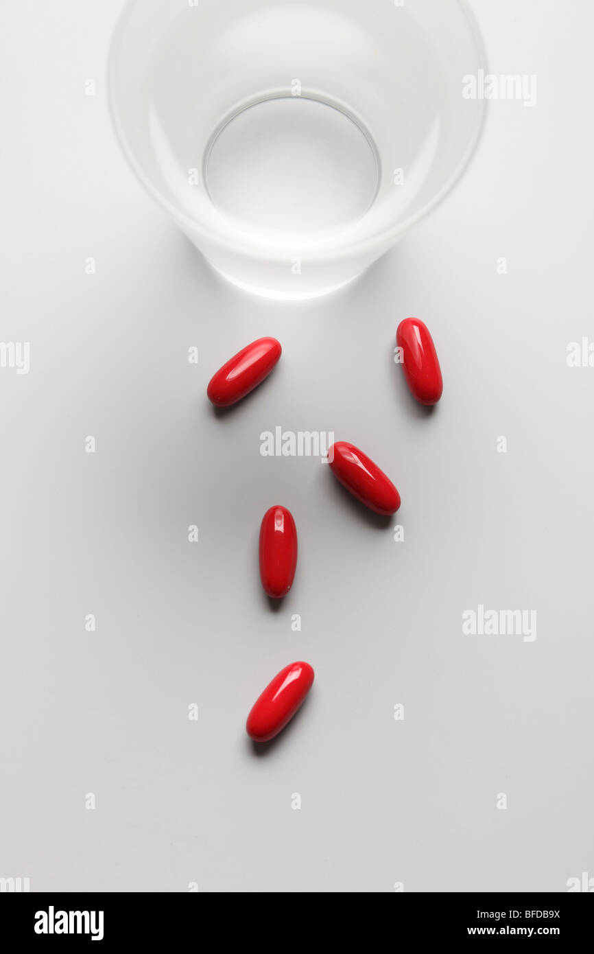 Tabletten neben einem Glas Wasser Stockfoto