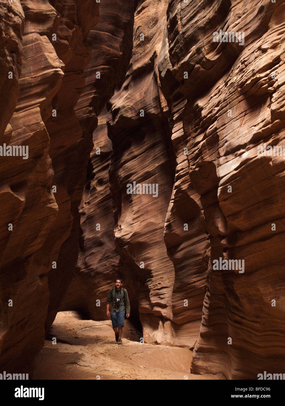 Ein Mann schaut beim Wandern in einem Slotcanyon in Utah. Stockfoto