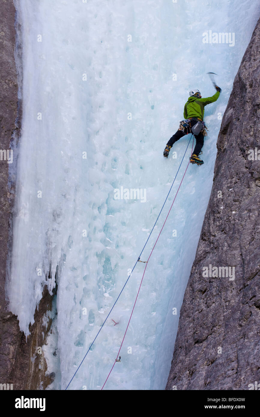 Ein Eiskletterer schwingt seine Axt ins Eis bei Ghost River, Alberta, Kanada Stockfoto Ein Eiskletterer schwingt seine Axt ins Eis bei Ghost River, Alberta, Kanada Stockfoto