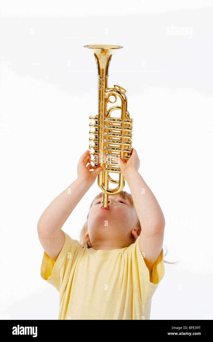 Junge mit langen blonden Haaren mit Spielzeug Trompete spielen Stockfoto