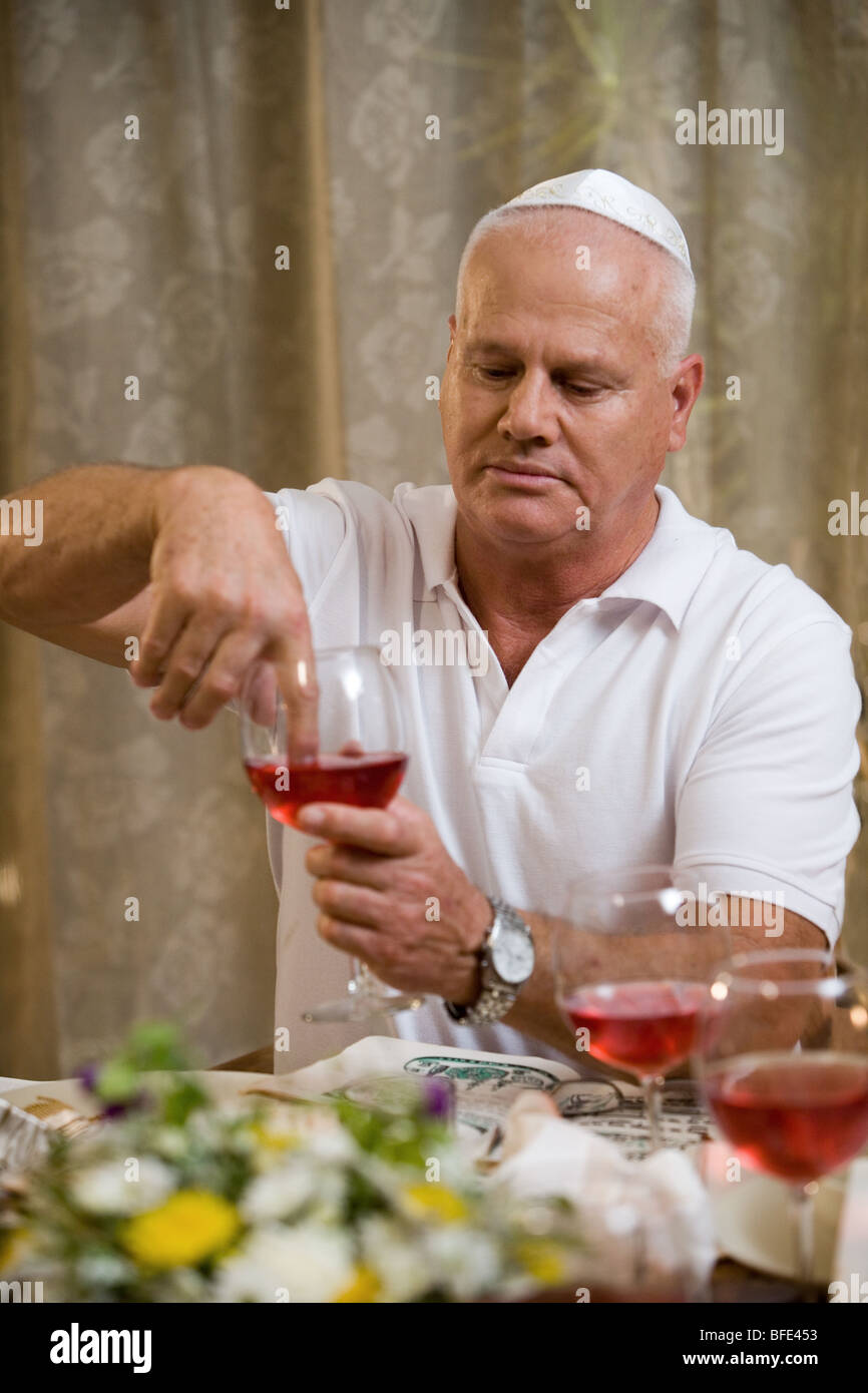 Eintauchen der Finger in Wein (Passah-Tradition). Stockfoto