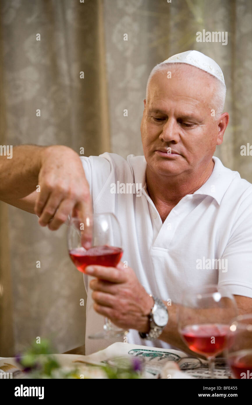 Eintauchen der Finger in Wein (Passah-Tradition). Stockfoto