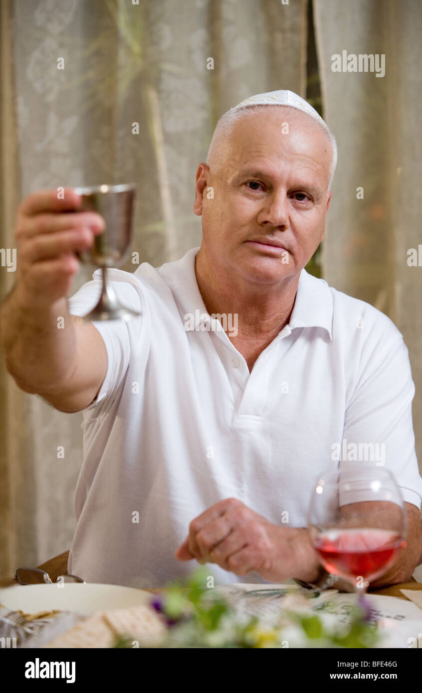 Mann mit Wein Silberpokal am Seder-Abend. Stockfoto