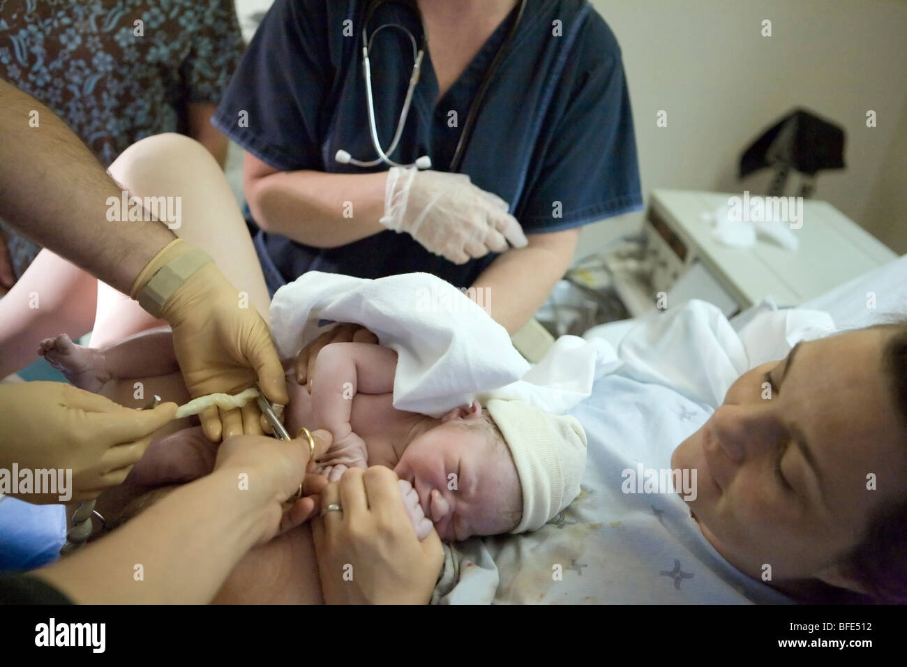 36 Jahre alte Frau mit ihrem Neugeborenen, da die Nabelschnur wird durchtrennt, Chateauguay, Quebec, Kanada Stockfoto