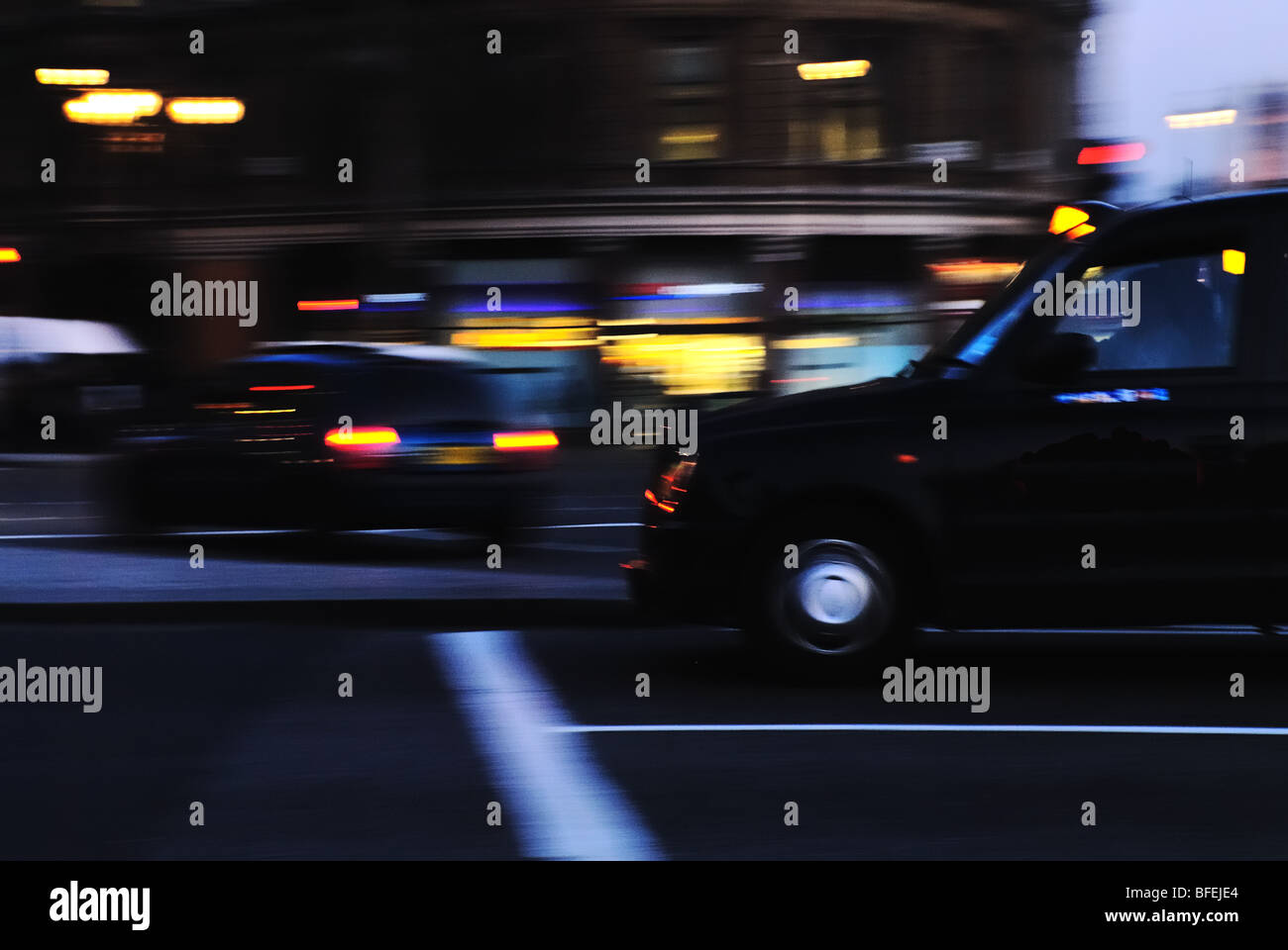 Ein schwarzes London-Taxi in Bewegung in der Abenddämmerung gefangen. Trafalgar Square, London, UK. Stockfoto