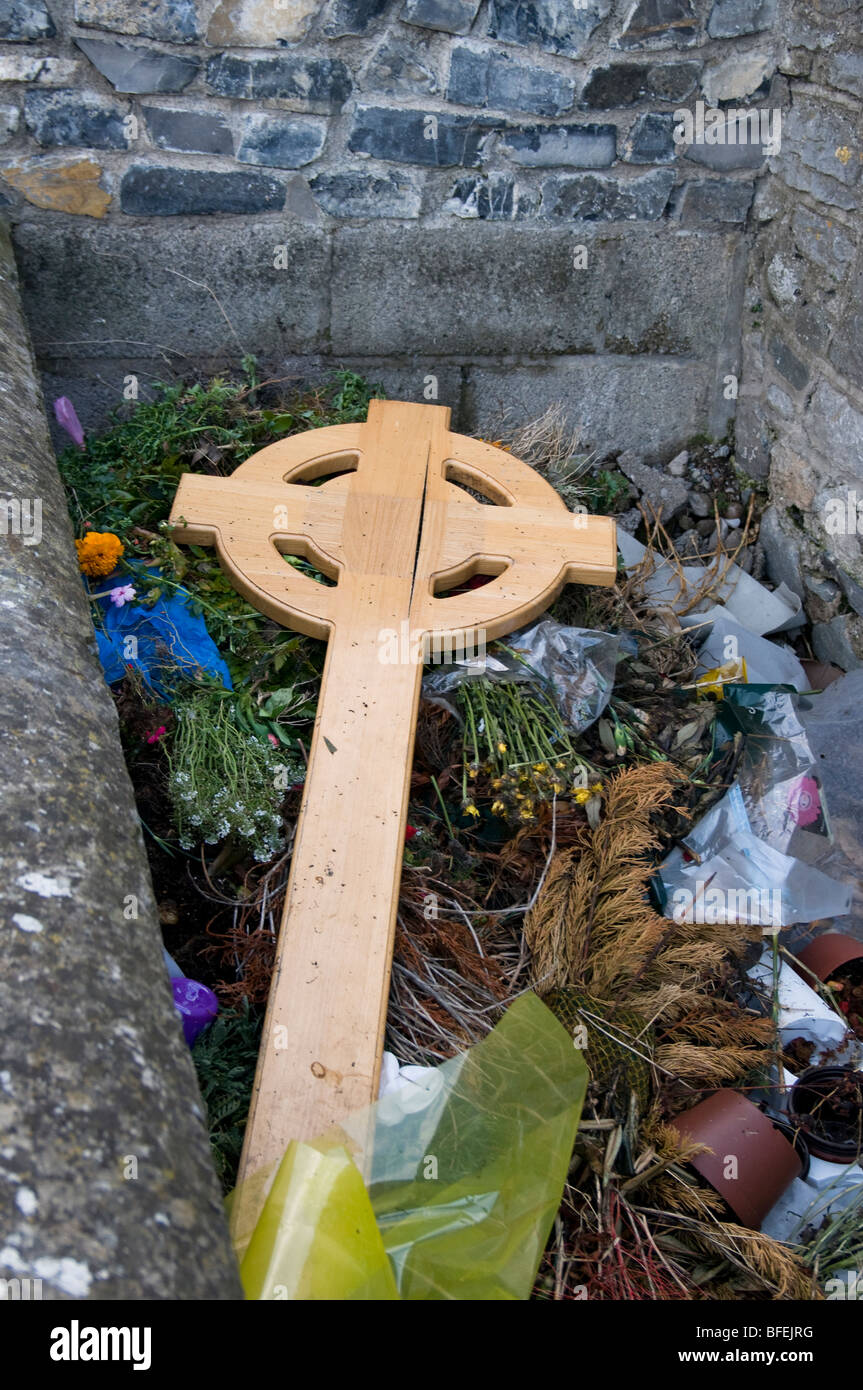 Wurde ersetzt durch einen Stein Grabstein ist eine temporäre Holzkreuz im keltischen Stil jetzt in einem irischen Friedhof weggeworfen Stockfoto