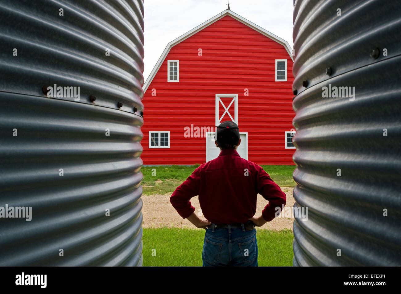Nahaufnahme des Getreidesilos mit Mann und rote Scheune im Hintergrund in der Nähe von Torquay, Saskatchewan, Kanada Stockfoto