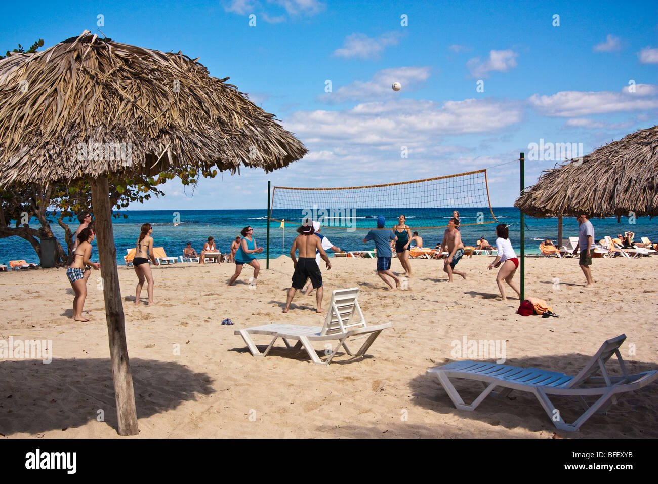 Menschen spielen Beach-Volleyball, Ball in der Luft greifen, Kuba, Karibik Stockfoto
