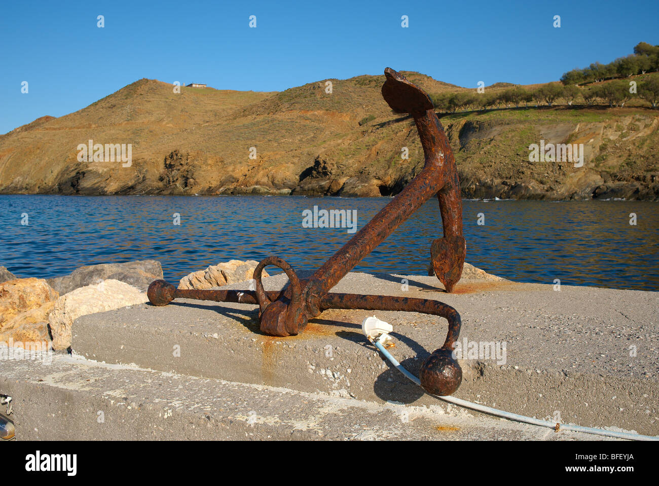 Riesige alte Anker liegend auf der Hafenmauer in Panormo, Kreta-Griechenland Stockfoto