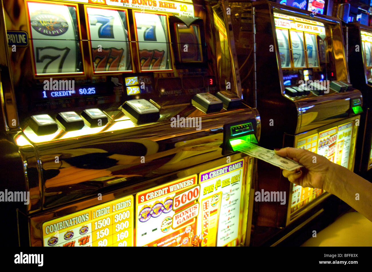 Handanlage einen fünf-Dollar-Schein in einem Slot-Maschine Stockfoto