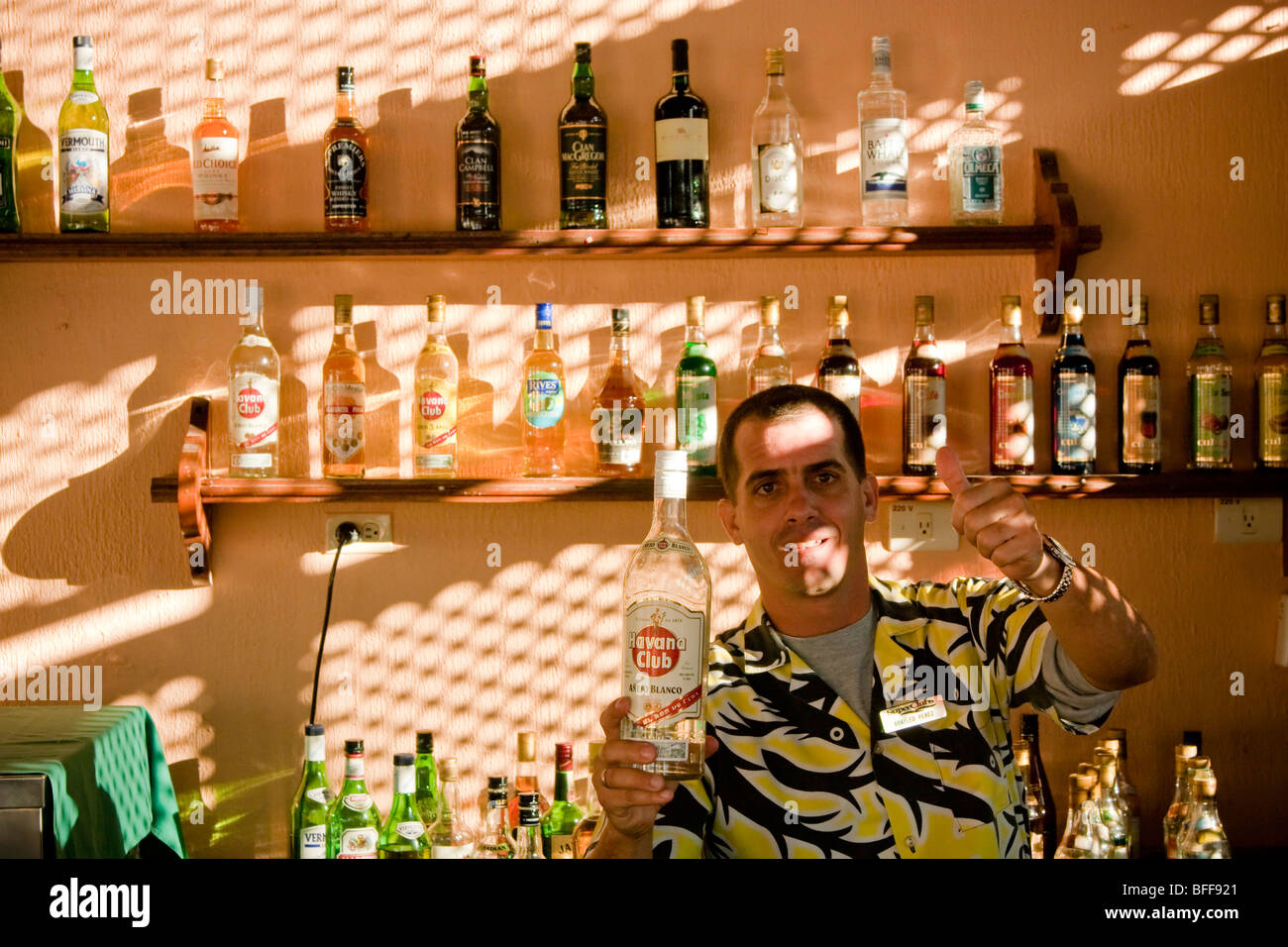 Barkeeper in einem kubanischen Resort hält eine Flasche Rum Havana Club weiß Stockfoto
