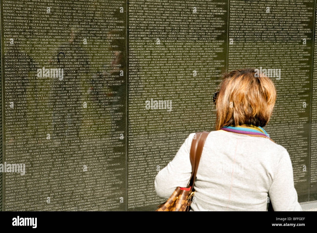 Eine Frau liest die Namen an der Wand bei der Vietnam Veterans War Memorial, Washington DC USA Stockfoto