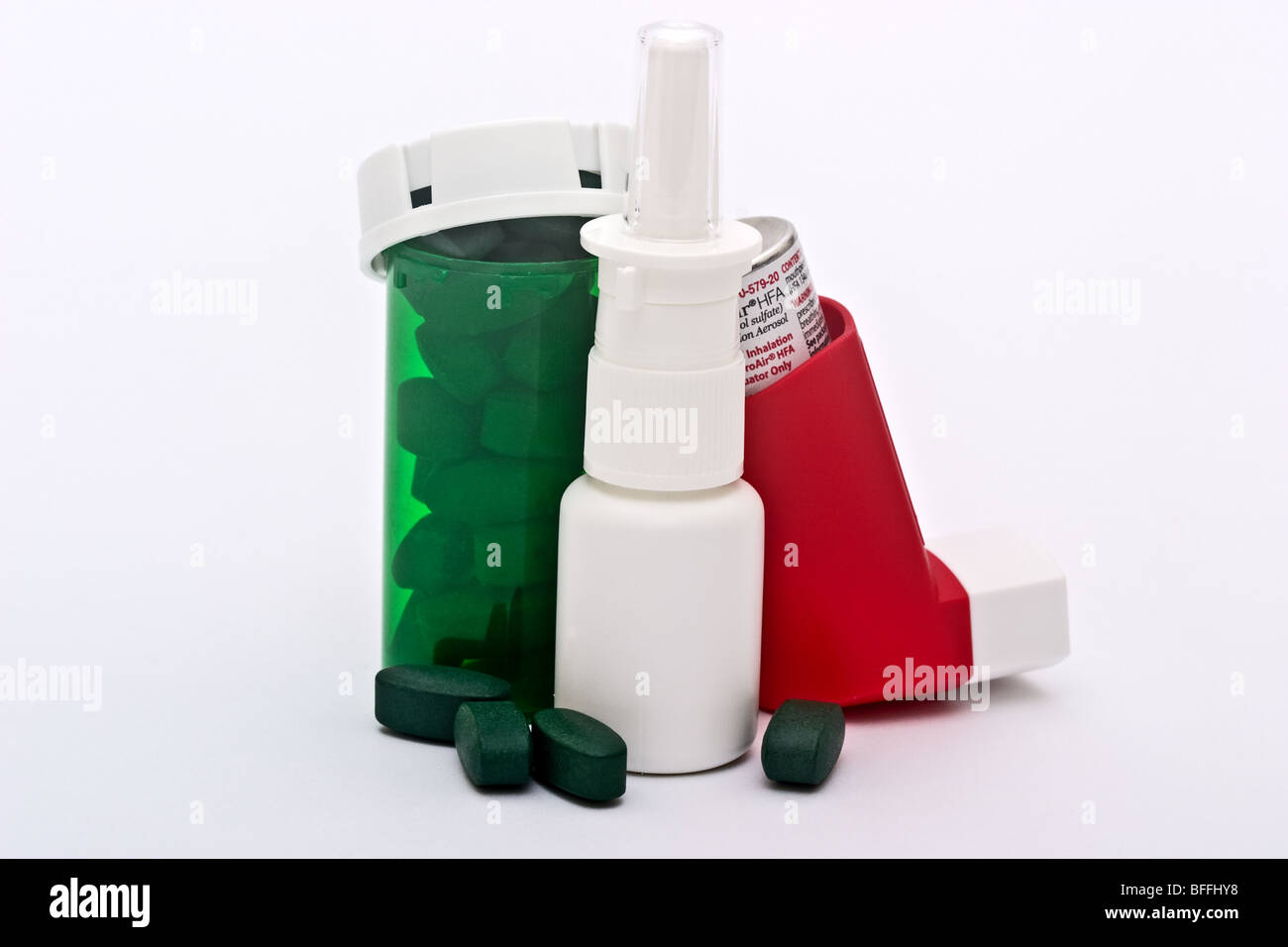 Eine grüne Medizin-Flasche gefüllt mit Pillen, ein Nasenspray-Container und einen Inhalator Stockfoto