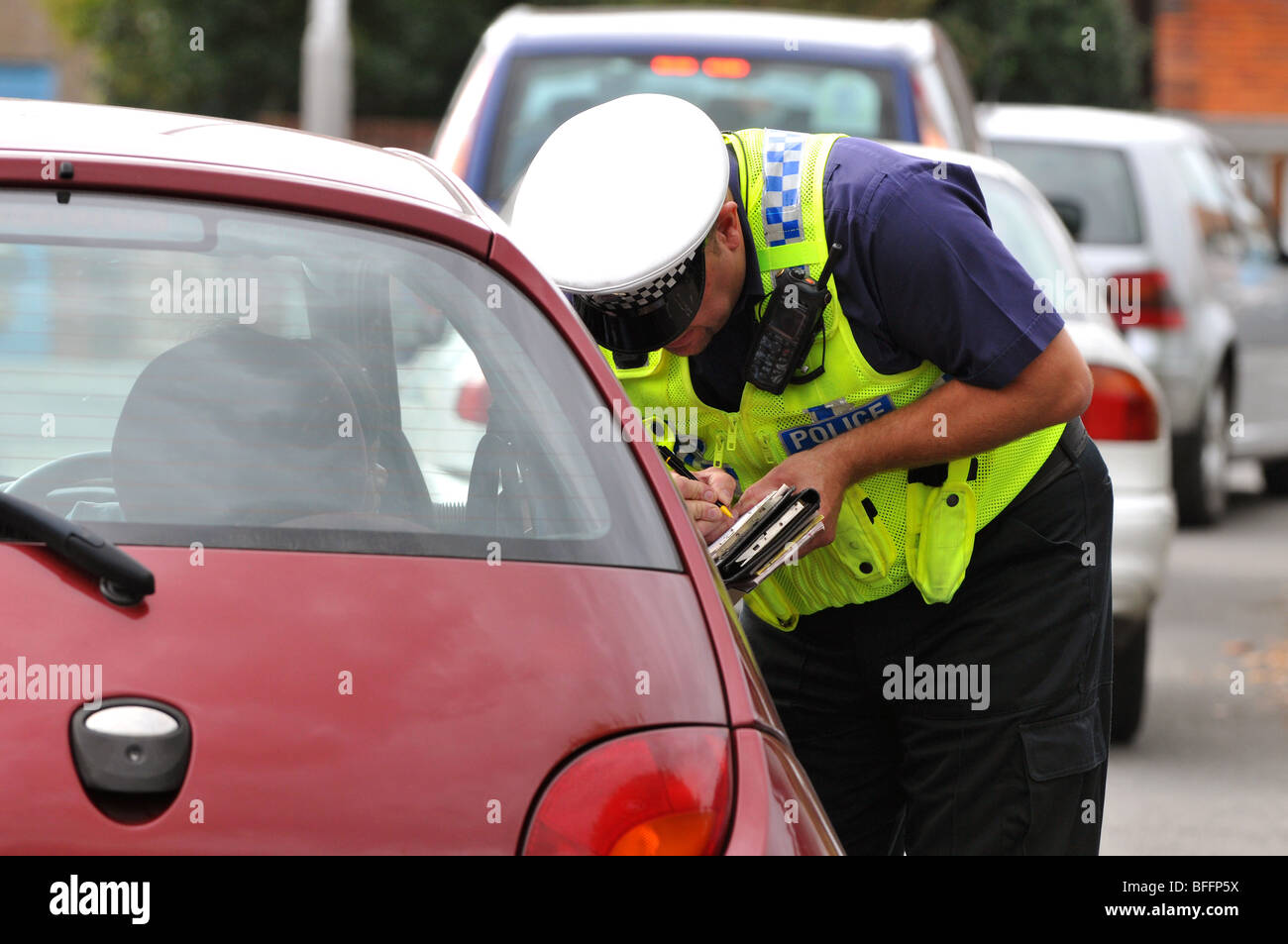 Polizist stellt ein Ticket zu einem Fahrer eines Autos, England, UK Stockfoto