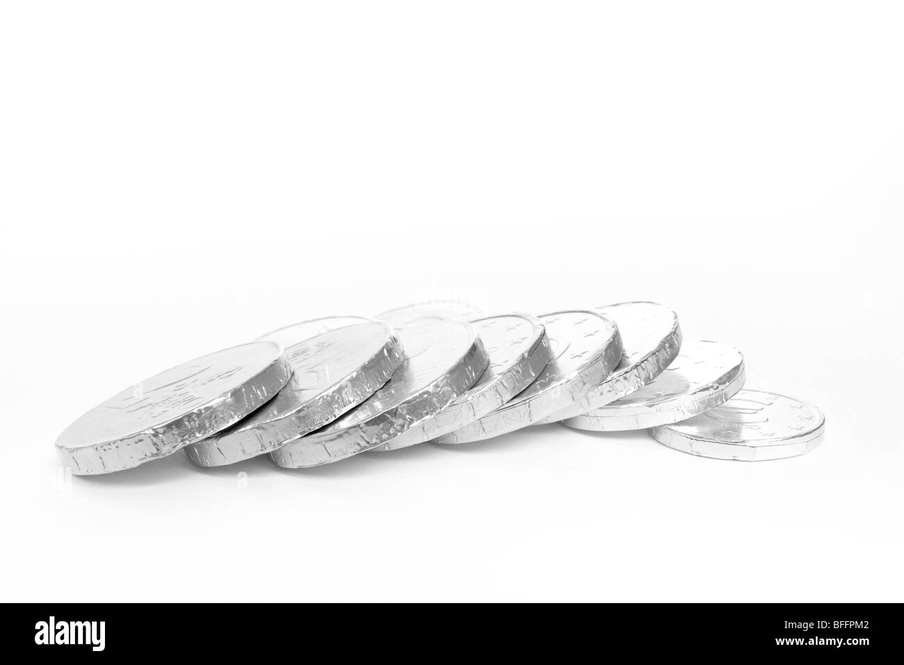 Monochromatisches Bild der Folie verpackt Schokolade Euro vor weißem Hintergrund mit flachen Fokus. Stockfoto