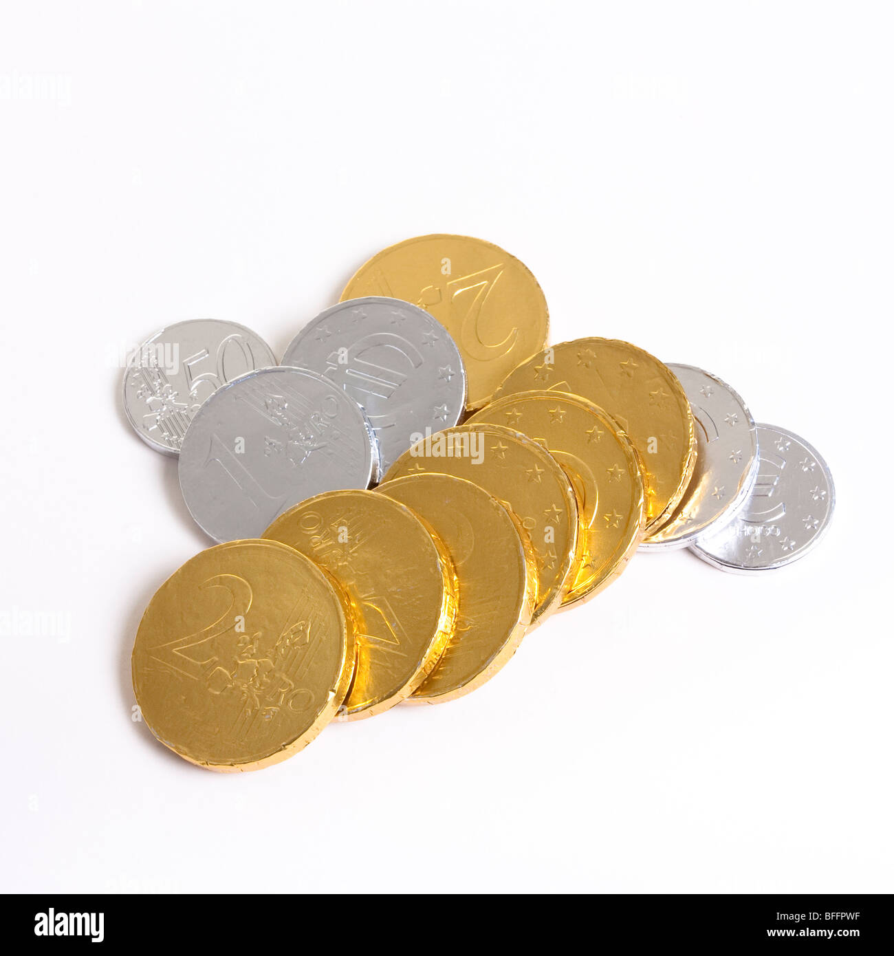 Gold und Silber Folie verpackt Schokolade Euro vor weißem Hintergrund mit flachen Fokus. Stockfoto