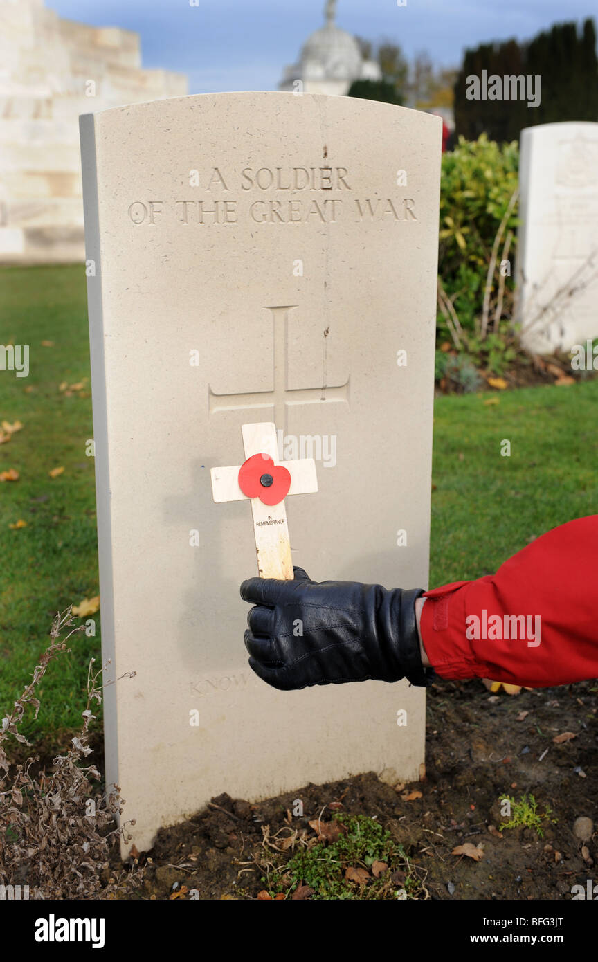 Verlegung von Mohn und hölzernen Kreuz am Grab des ersten Weltkrieges Soldat am Tyne Cot Friedhof Passchendale Ypern, Belgien Stockfoto