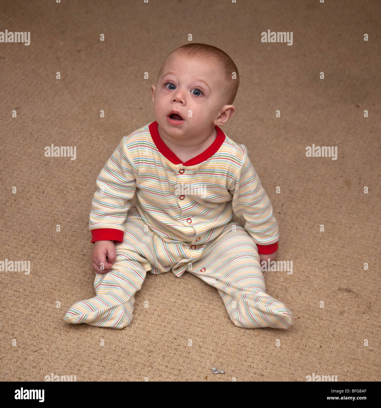 Sechs Monate alten Baby jungen sitzen auf dem Boden, London, England. Stockfoto