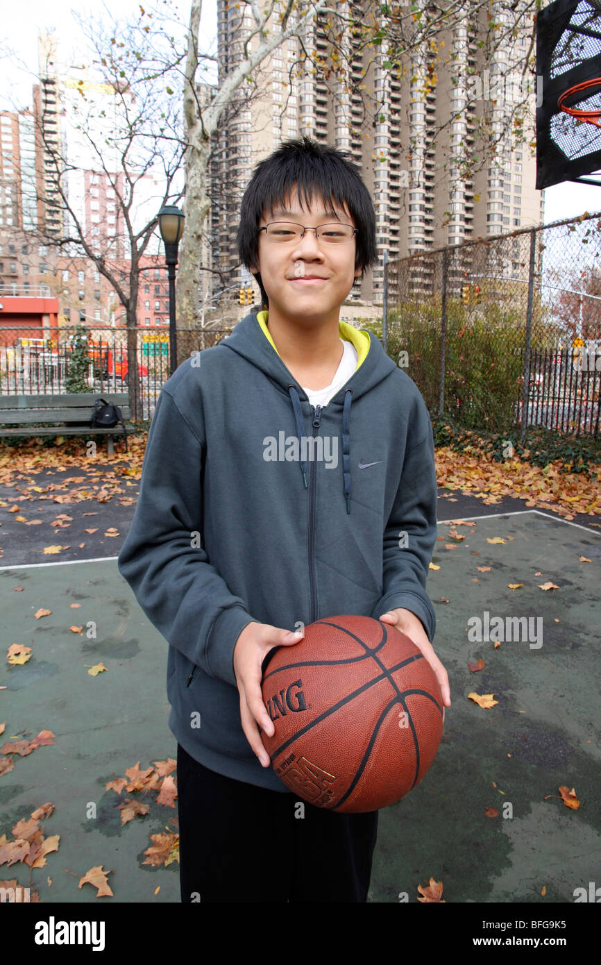 Porträt eines chinesisch-amerikanischen Pre Teen auf einem Basketballfeld. Stockfoto